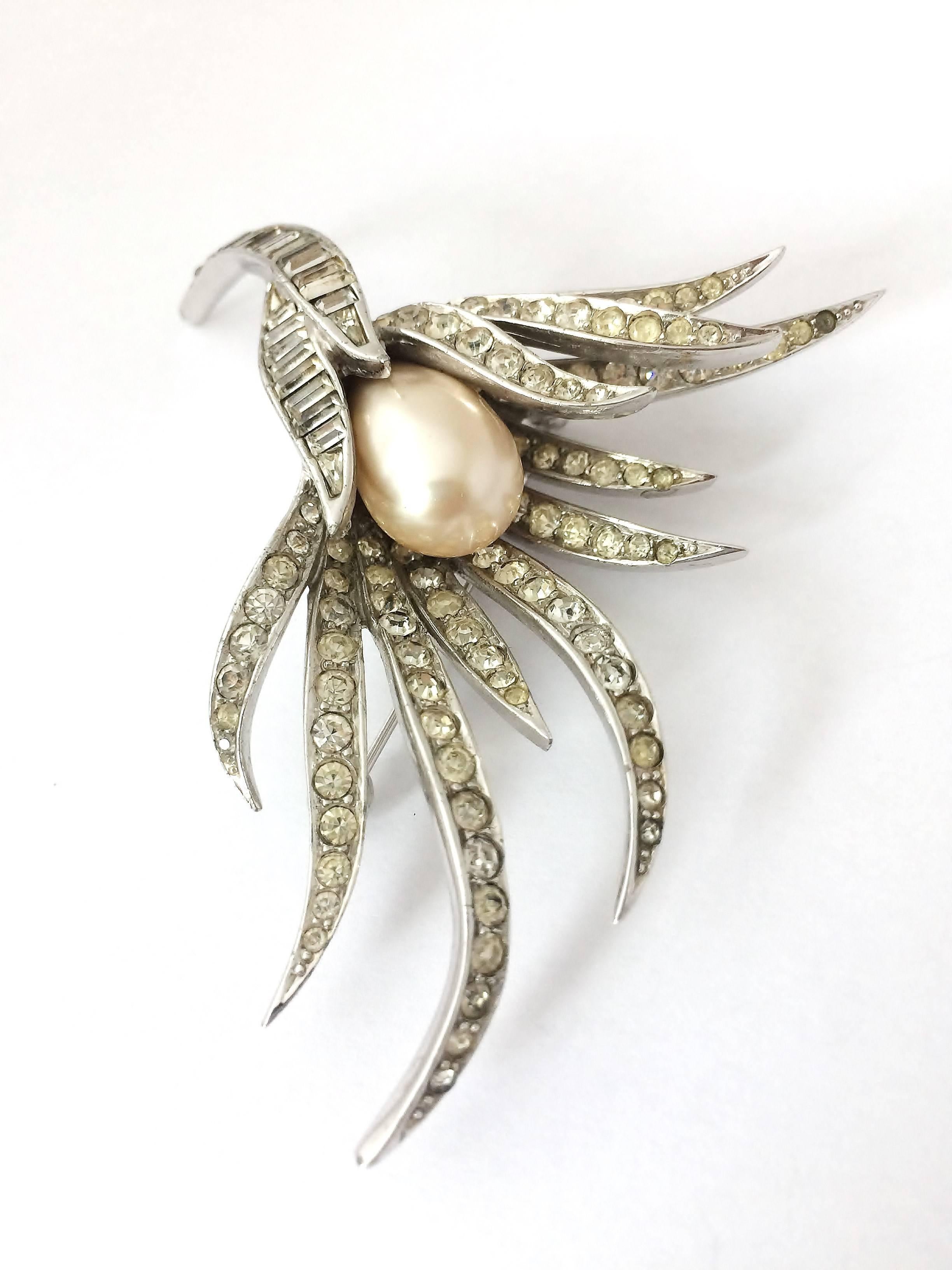 An exquisite brooch both in style and appearance from Marcel Boucher. White paste 'leaves' cradle a large baroque pearl, in a cascading spray brooch, redolent of Van Cleef and Arpels, and other jewellers of the period. As always, with Boucher, the