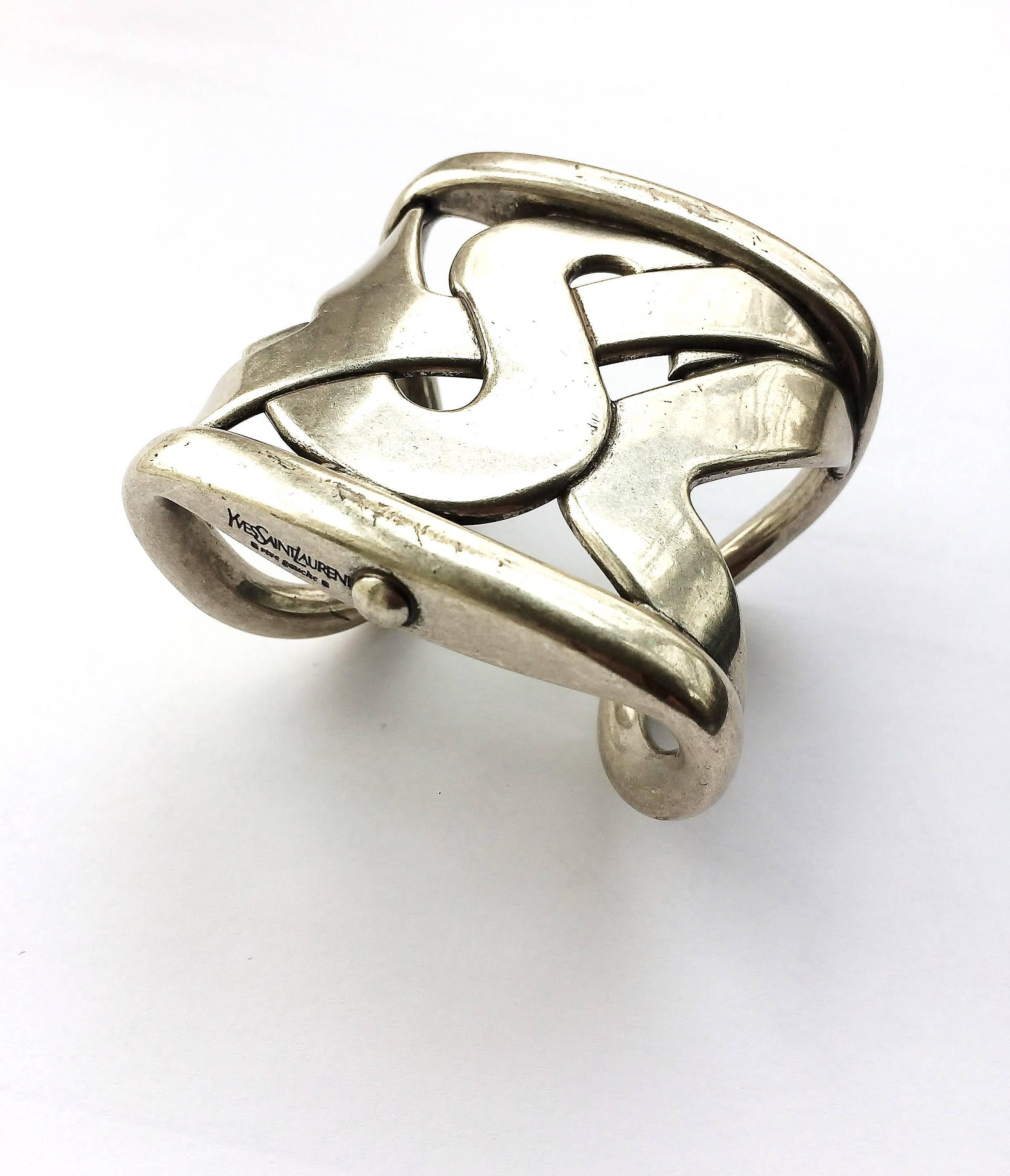 Strong statement cuff in silvered metal from Yves Saint Laurent, with its original box. Subtley designed and of the highest quality, this  bangle immediately states the design house's initials, while appearing abstract or Celtic in design at the