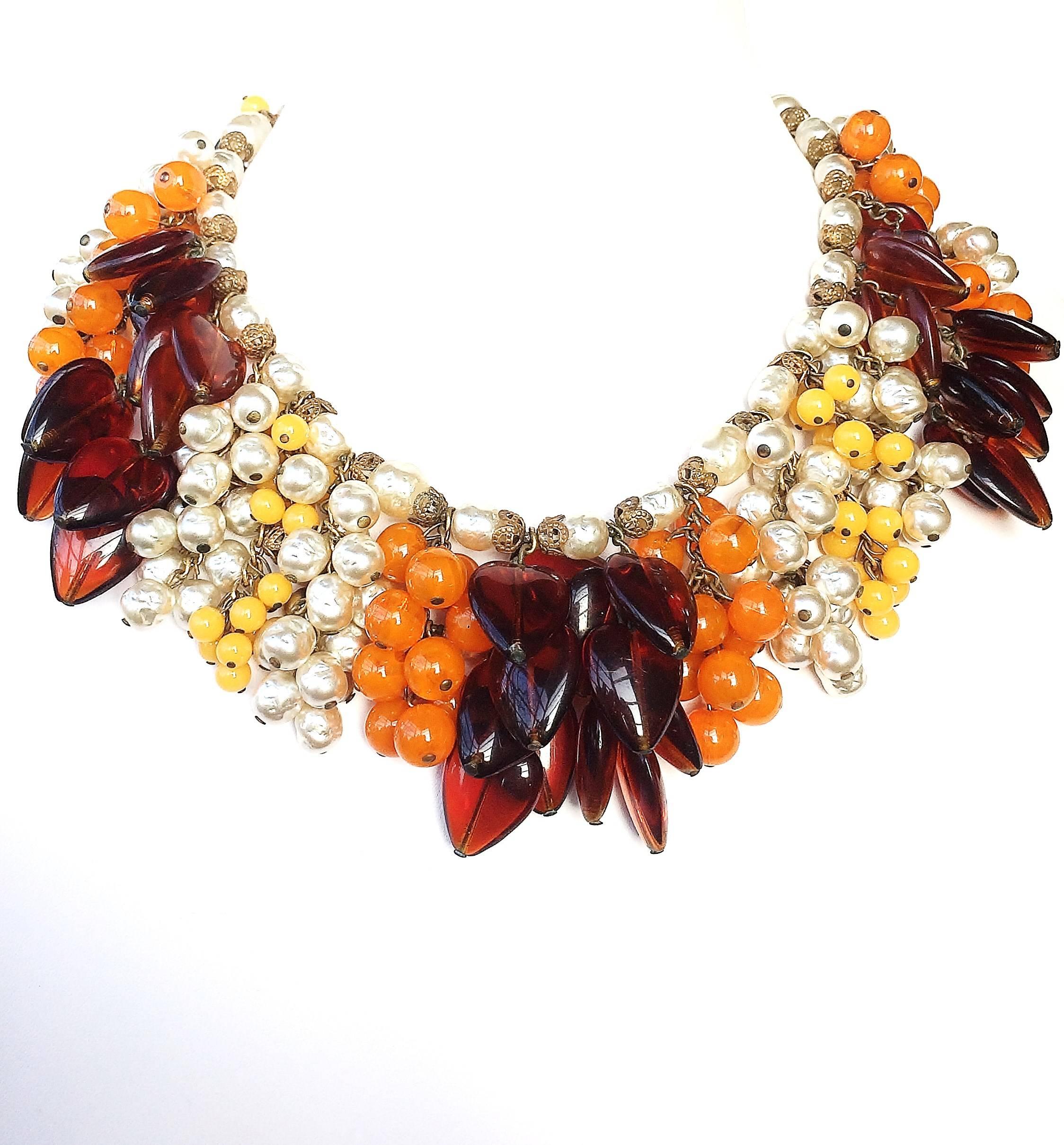A magnificent necklace and earrings, highly impressive and sumptuous, designed by Robert Clark for Miriam Haskell, made of signature baroque pearls and glass 'leaf' drops and glass beads, in orange, yellow and a rich brown, some opaque, some clear