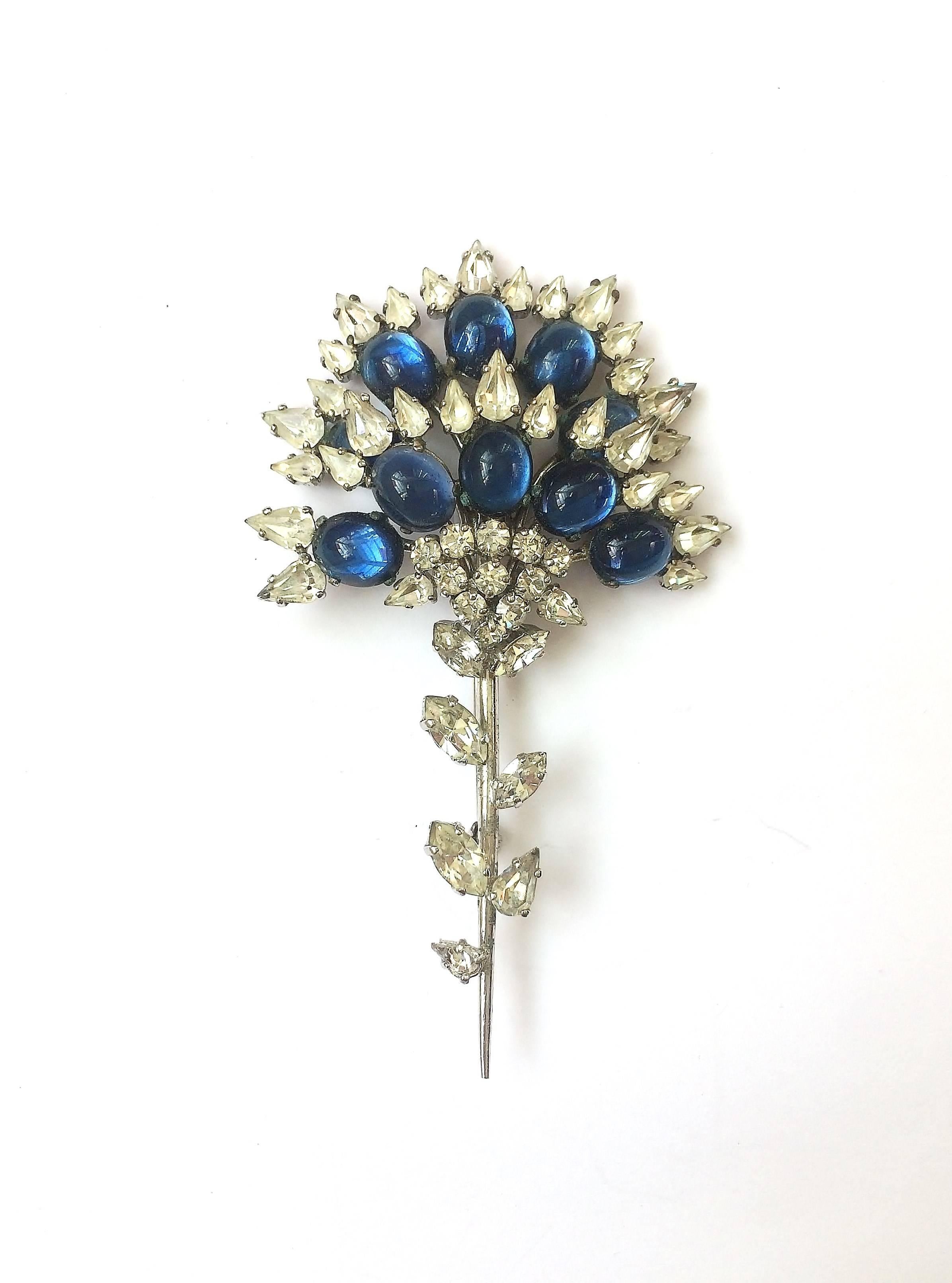 A splendid  stylised floral brooch, designed by Francis Winter, one of the great early designers for Christian Dior, and made in Germany by Henkel and Grosse, is made of deep sapphire paste cabuchons and clear paste, some open backed, others prong
