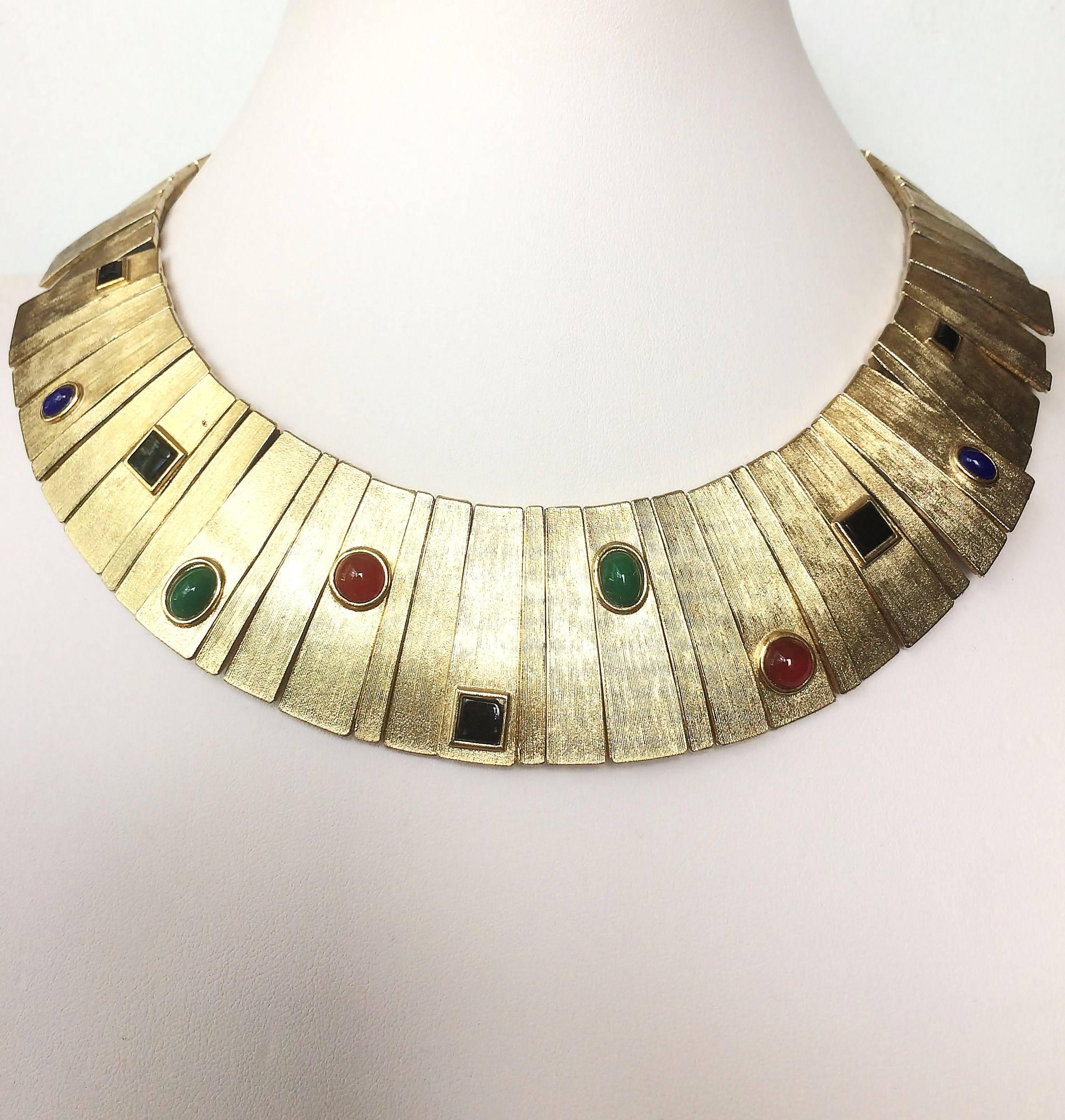 A very smart and striking collar from Les Bernard in the 1970s, made of base metal with a satin soft gilt lustre and highlighted with assorted square cut and cabuchon paste stones . An architectural design. it is mounted on chain so articulated and