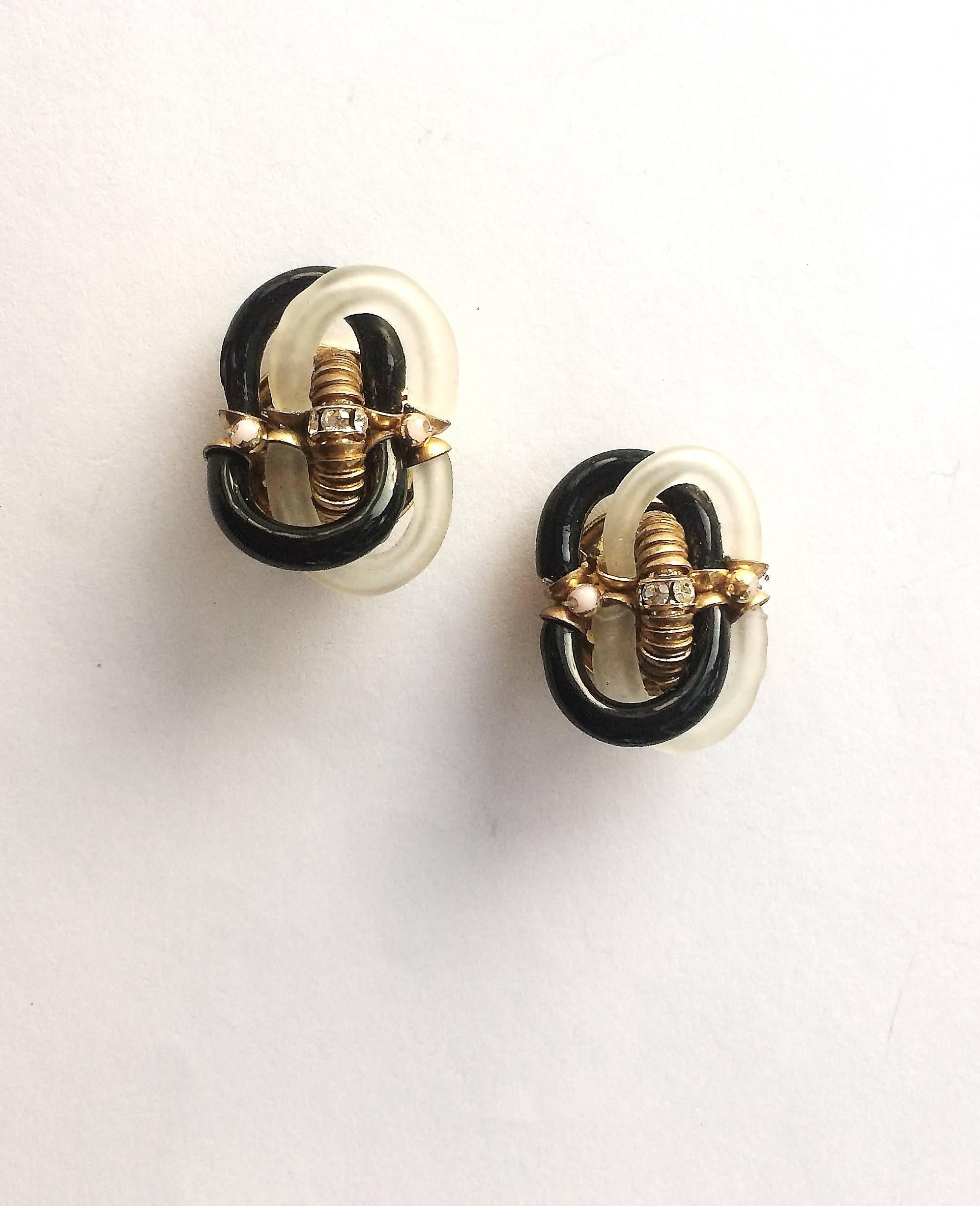 Made by the famous Venetian glass maker Seguso for chanel in the 1970s, these sculptural earrings are constructed of two interlocking curved pieces, in black and frosted glass, with gold and paste highlights. Although unsigned, this is a well known
