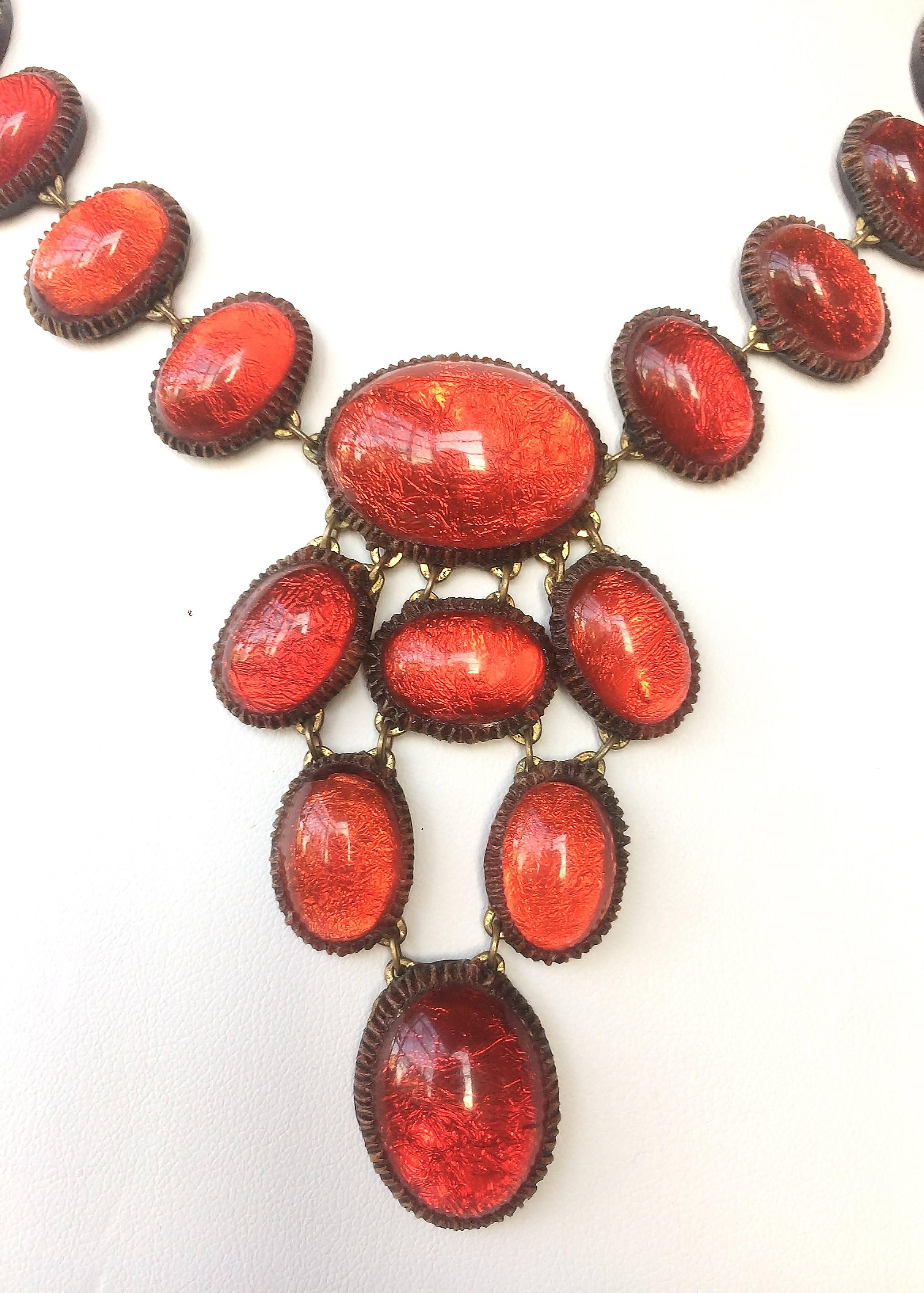 A ravishing and dynamic colour of red gives this talousel and foil necklace its seductive charm.
In the style of Line Vautrin (but not created by her workshop), this necklace is very light and easy to wear, lighting up the face of whoever wears it.