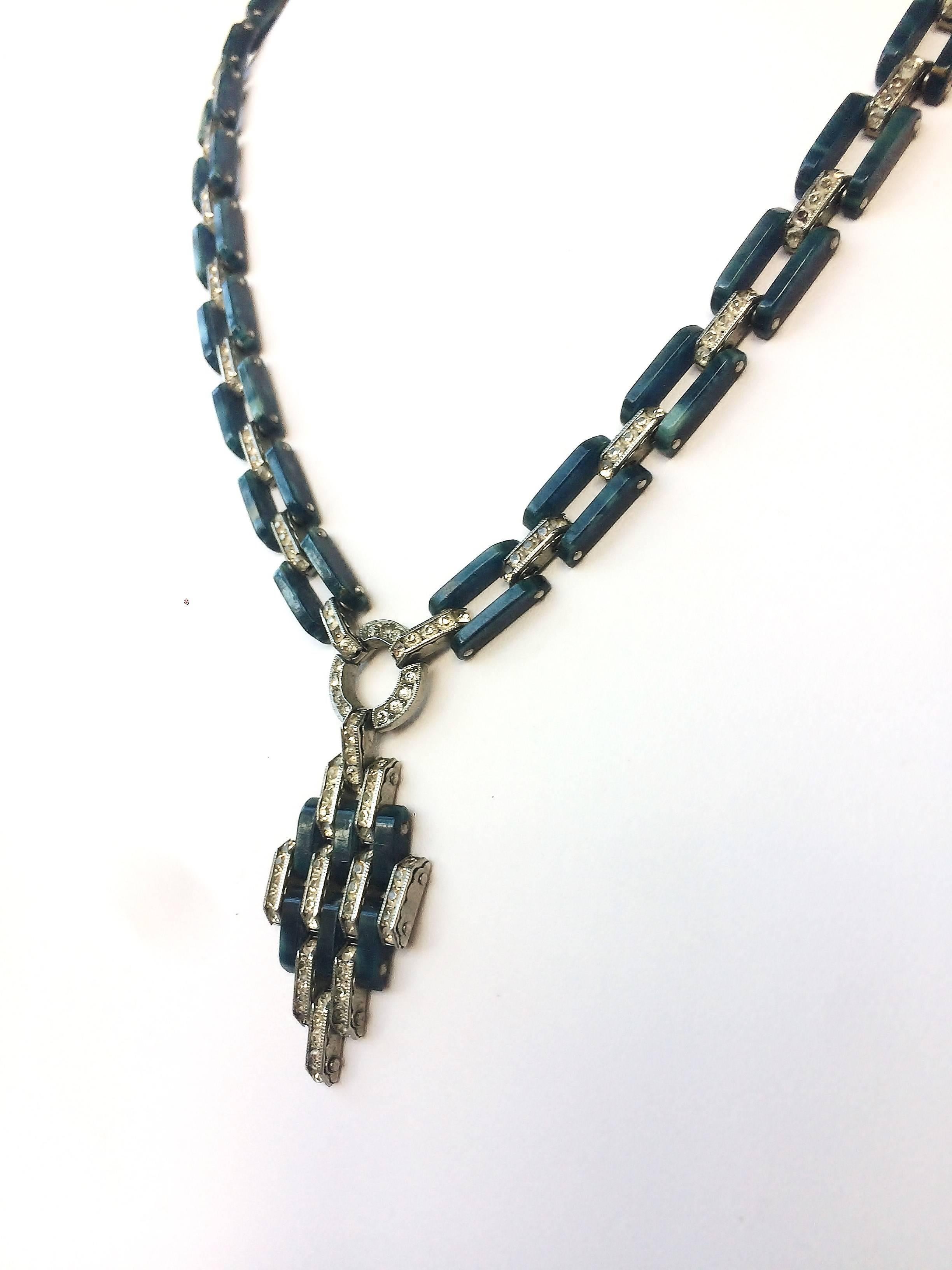In excellent condition with clear channel set pastes and  chain links in an unusual petrol/dark blue marbled Bakelite, this very stylised, high Art Deco necklace is stamped 'D.R.G.M.', a mark very well know amongst Art Deco jewellery aficionados.