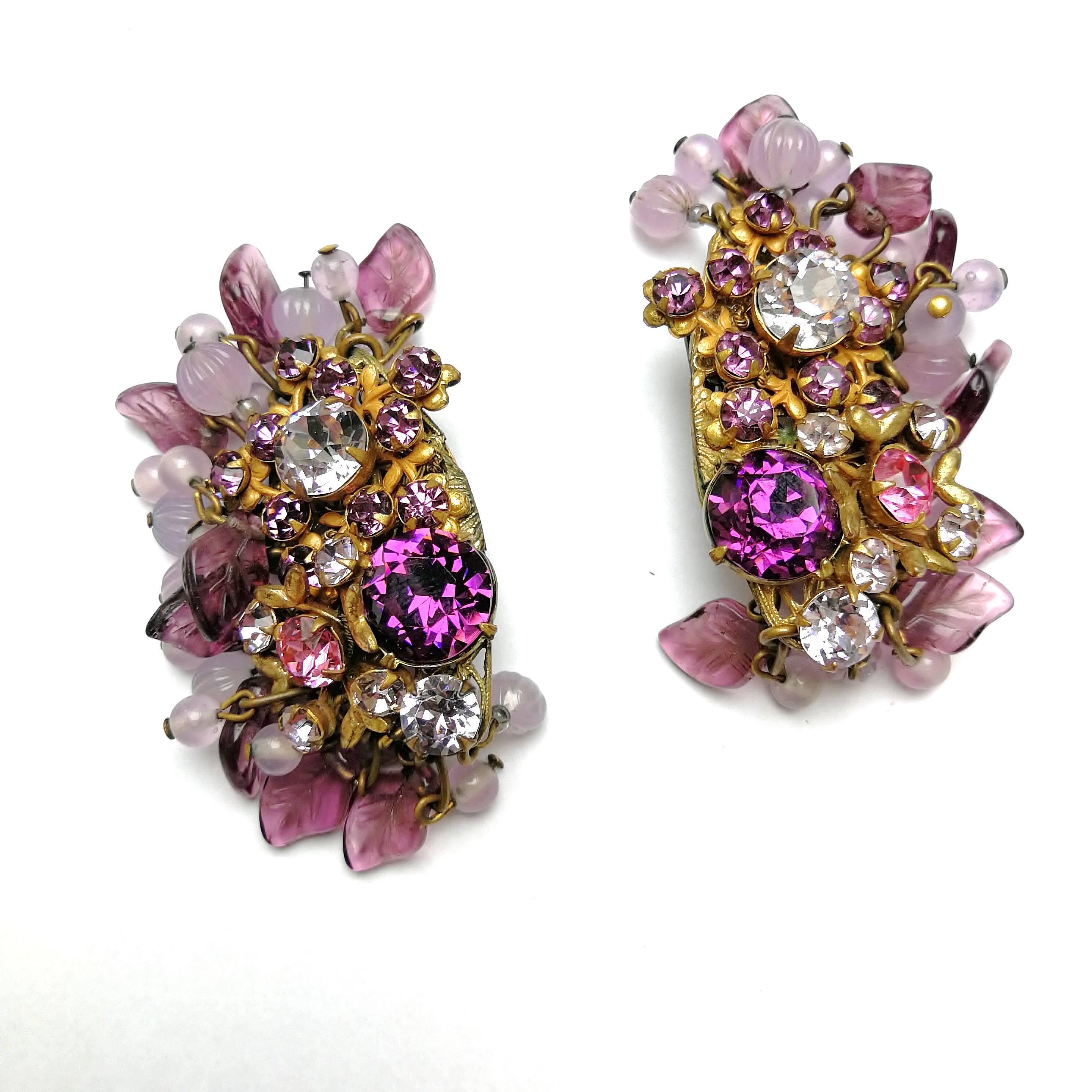 A large and very glamorous pair of Miriam Haskell earrings, in ravishing lilacs, purples and pinks, with moulded leaf elements, melon cut and regular beads cascading from the outer edge of each earring. A statement earring but with a sublety and