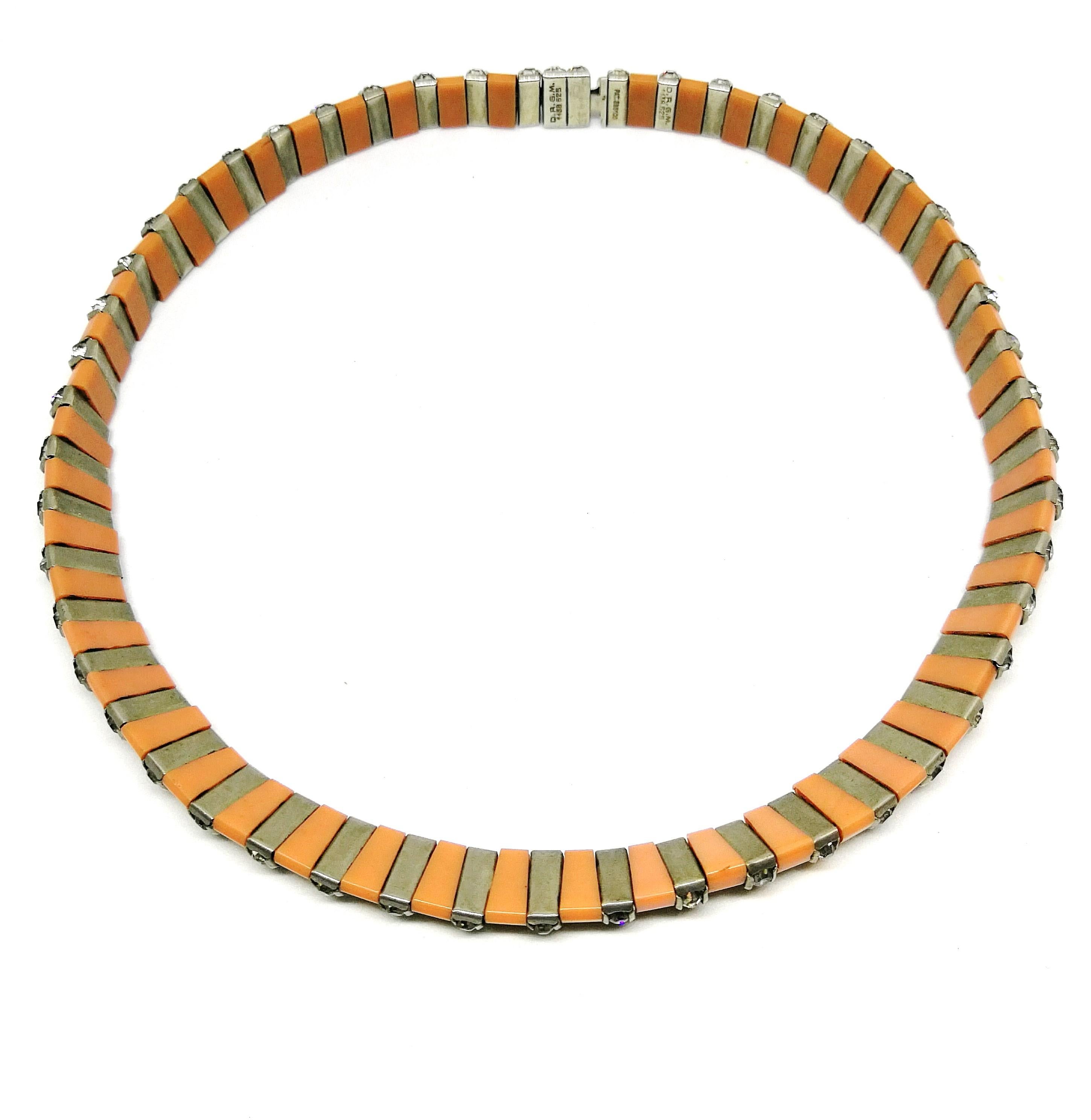 Styled in the highly characteristic manner of all D.R.G.M pieces, this particular necklace is in a very unusual hue of Bakelite. Whereas most pieces use black Bakelite, this elegant and simple necklace is made in a soft salmon pink, interspersed