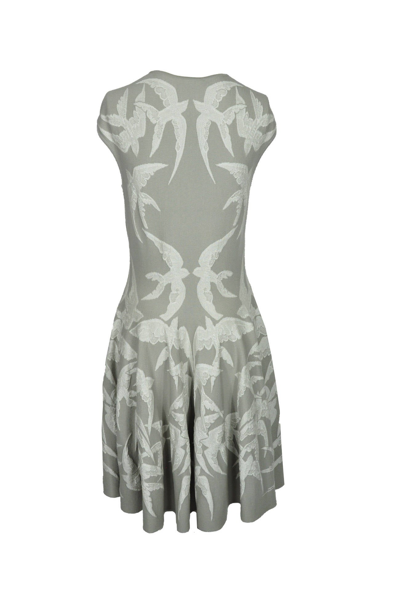 A slip on Alexander McQueen capped sleeves dress features a fitted silhouette with all over swallow embroidery. This knee length style nips in at the waist and has gentle pleating at the skirt. Size is medium