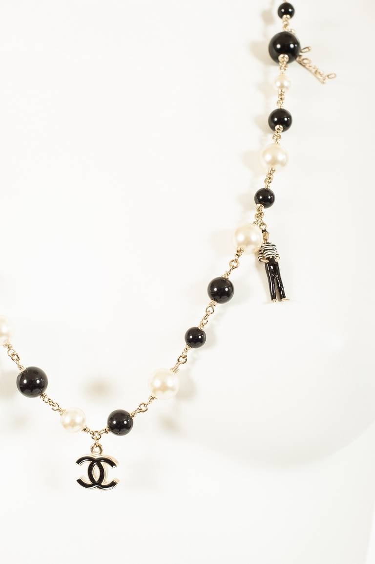 A very rare black and white pearls interspersed with multiple charms - gondola, gondolier, cc logo, to match the theme.  Hook clasp closure.
Total Length: 36 inches