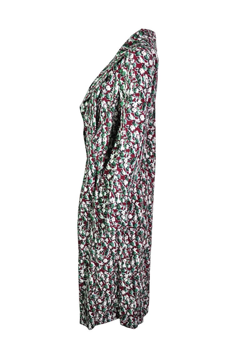 A fluid colorful floral print duster coat in silk from Marni. It features with two black self-tie fastenings at front.  High slits at both sides.