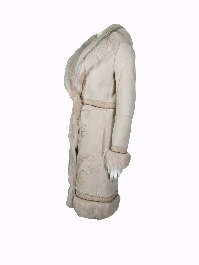 A very luxurious and stylish shearling coat in nude and beige color. It features with a removable fox collar and python embroidery. It is fully trimmed with leather, suede and eyelet. Two side pockets. Fur hook closure.