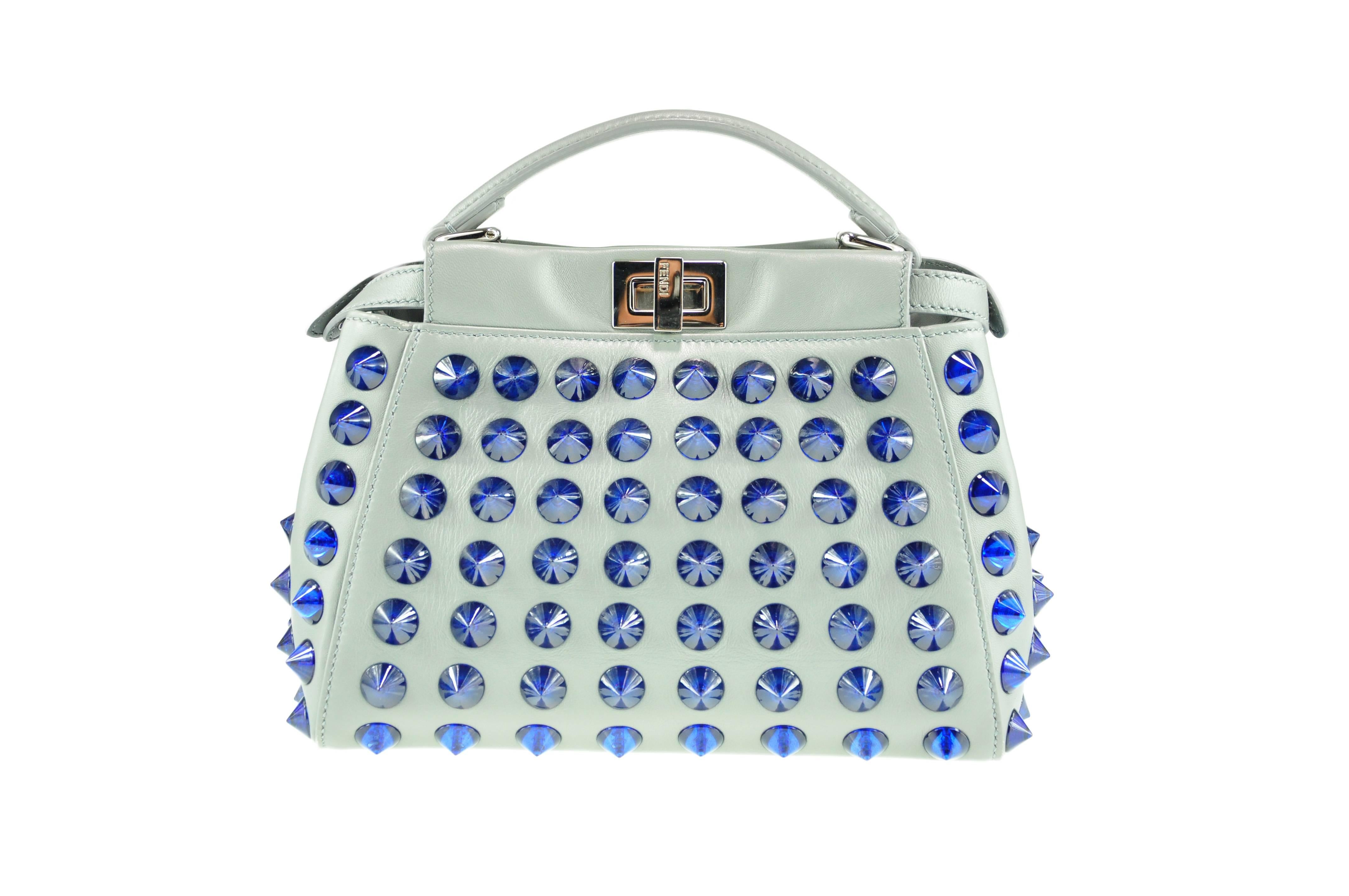 A most coveted Fendi mini Peekaboo in grey smooth nappa leather with cobalt conical studs.  Silver tone hardware, two compartments, one interior slip pocket and zip pocket.  Flat leather top handle, adjustable and detachable shoulder strap, turn