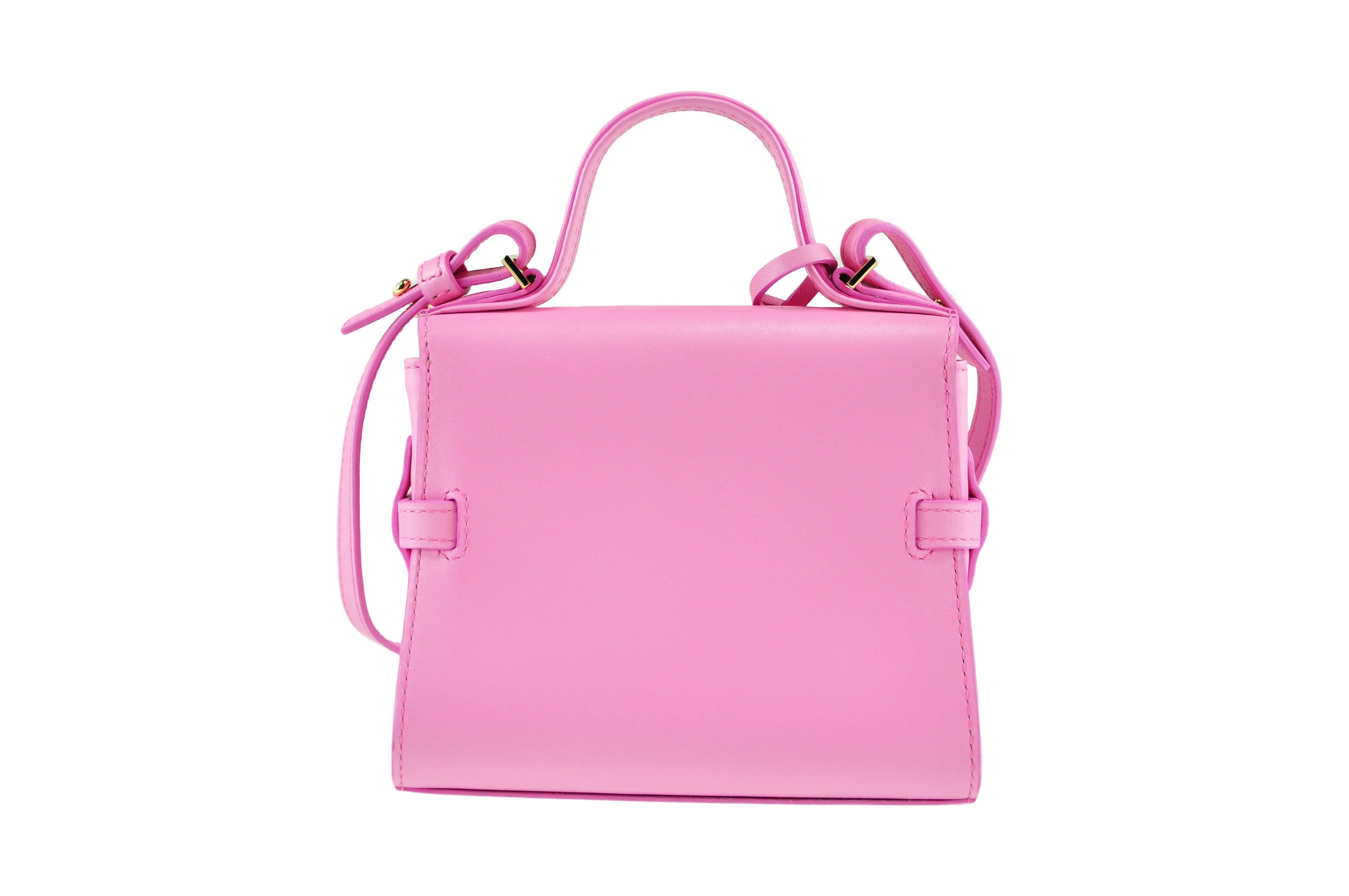 A sold-out stunning pink Delvaux tempete micro bag features with threaded strap at side secures with adjustable metal plates at front. Gold tone hardware with protective tape, one interior slip pocket, lined with natural smooth leather.  Flat top