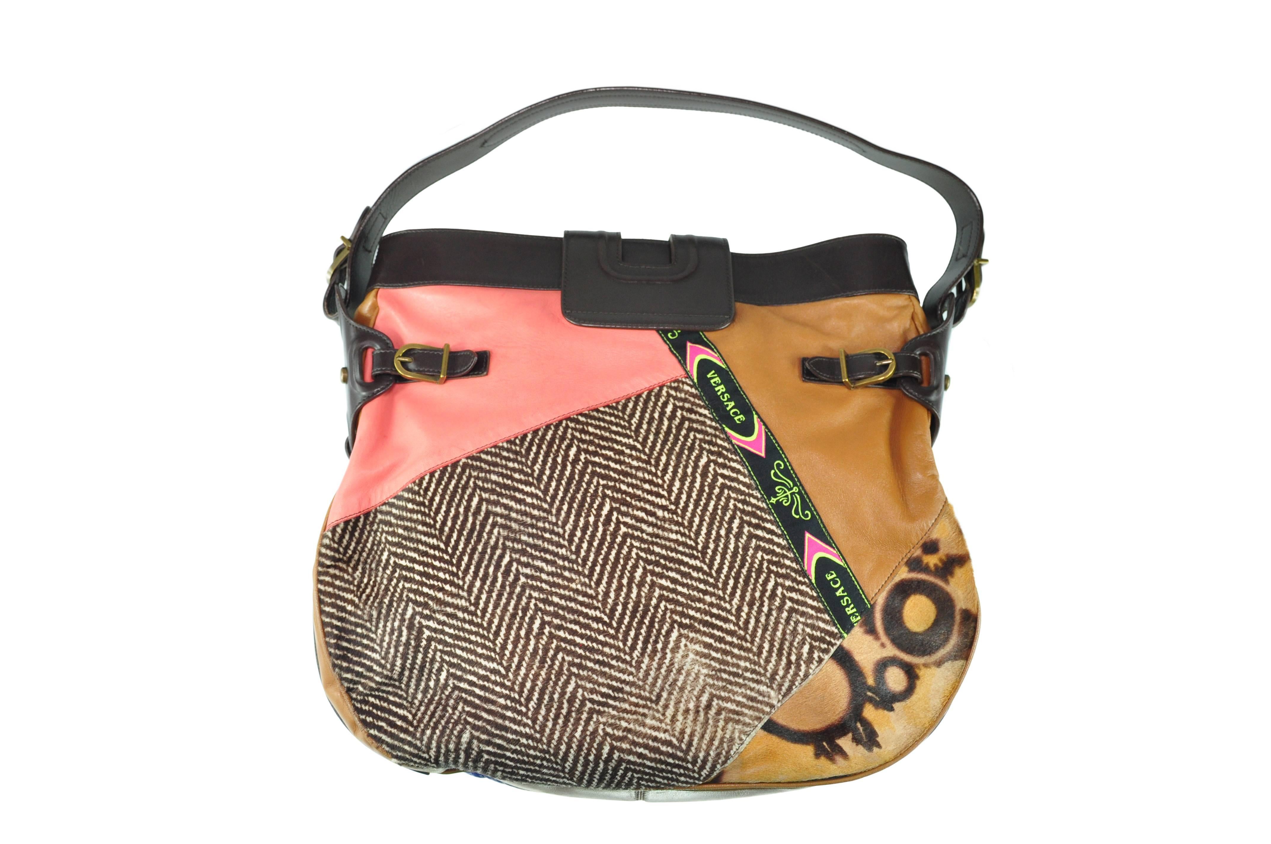A rare and beautiful crafted patchwork shoulder bag from Gianni Versace in the 90's, the patchwork is combination of animal printed on cowhide skin, suede eyelets, eel skin. Leather buckle on top with a snap closure.  Single leather shoulder strap.