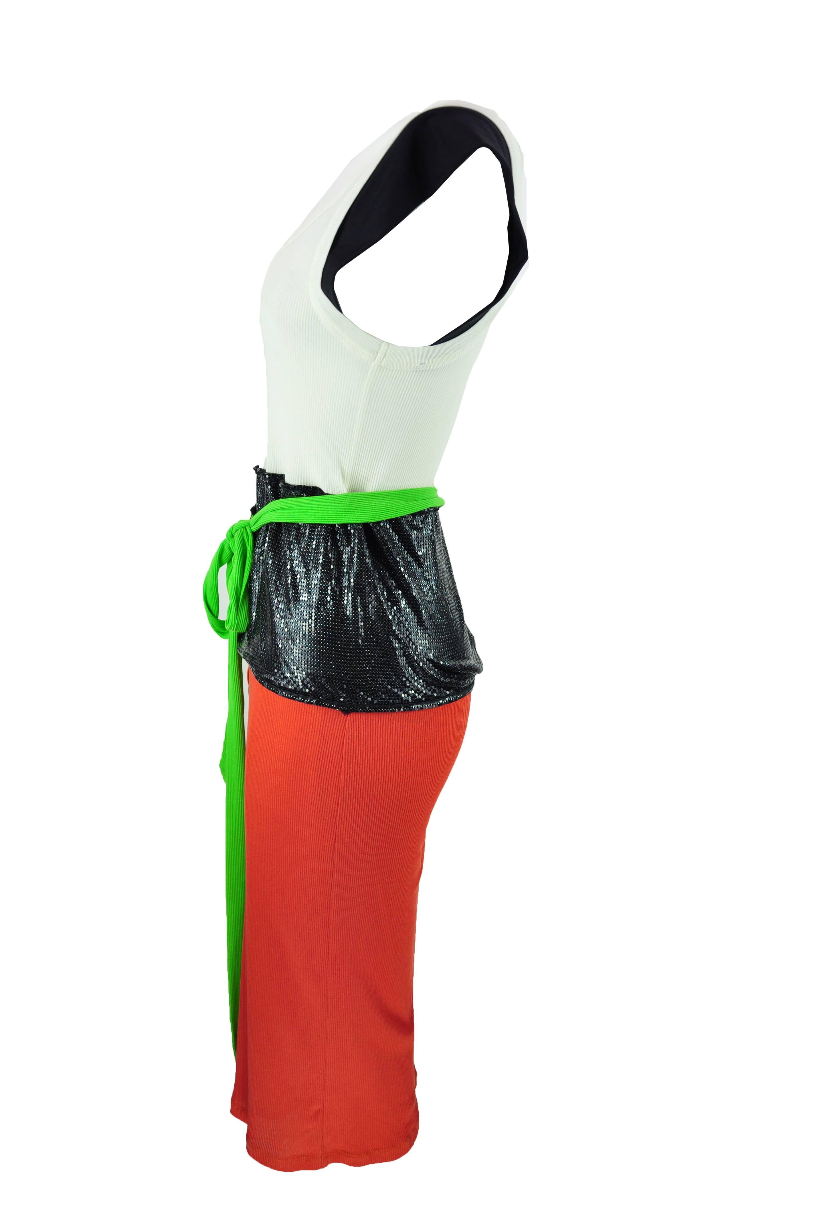 This dress is tailored with different elements. It features black cap sleeves white top and an attached red skirt wrapped around with black chain mail and green ties at waist.  The skirt is lined. The size is medium.
