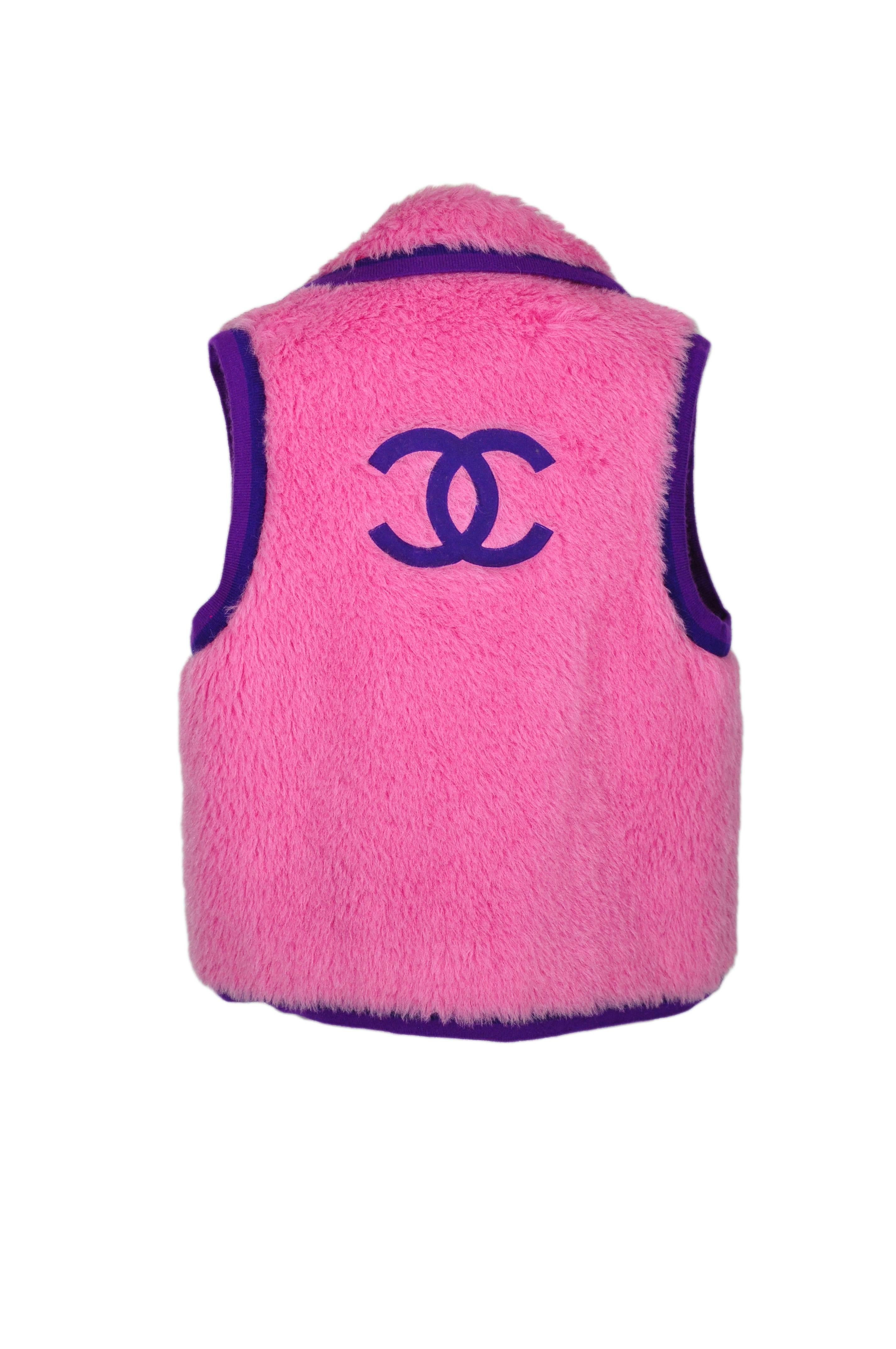 A rare Chanel classic 4 pockets collared vest in hot pink color contrasted with  violet/aubergine cashmere trimmings and decorated with a large CC logo at back. Fully lined in silk. 