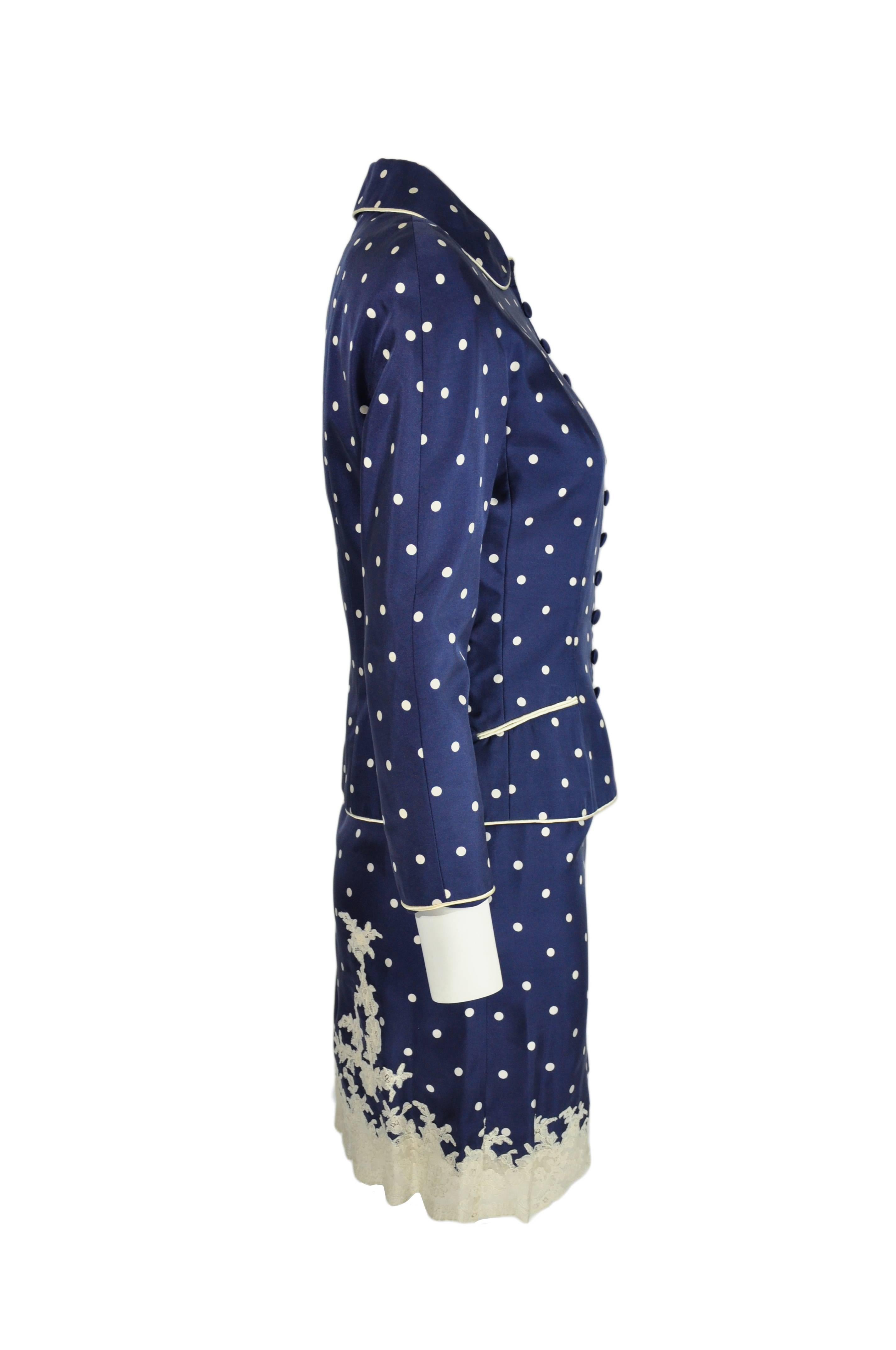 This classic and timeless navy polka dot silk jacket and skirt with lace hem is from Christian Dior by John Galliano in 90's.  The jacket features button fastening through front with two welt pockets, white pipping and fully lined. The skirt