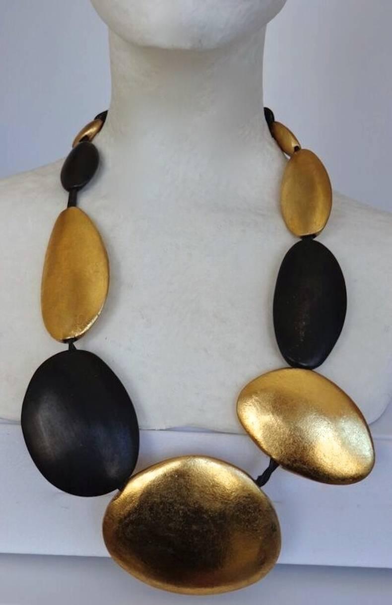 Gold leaf and ebony wood necklace with leather and wood closure from Monies. 

26