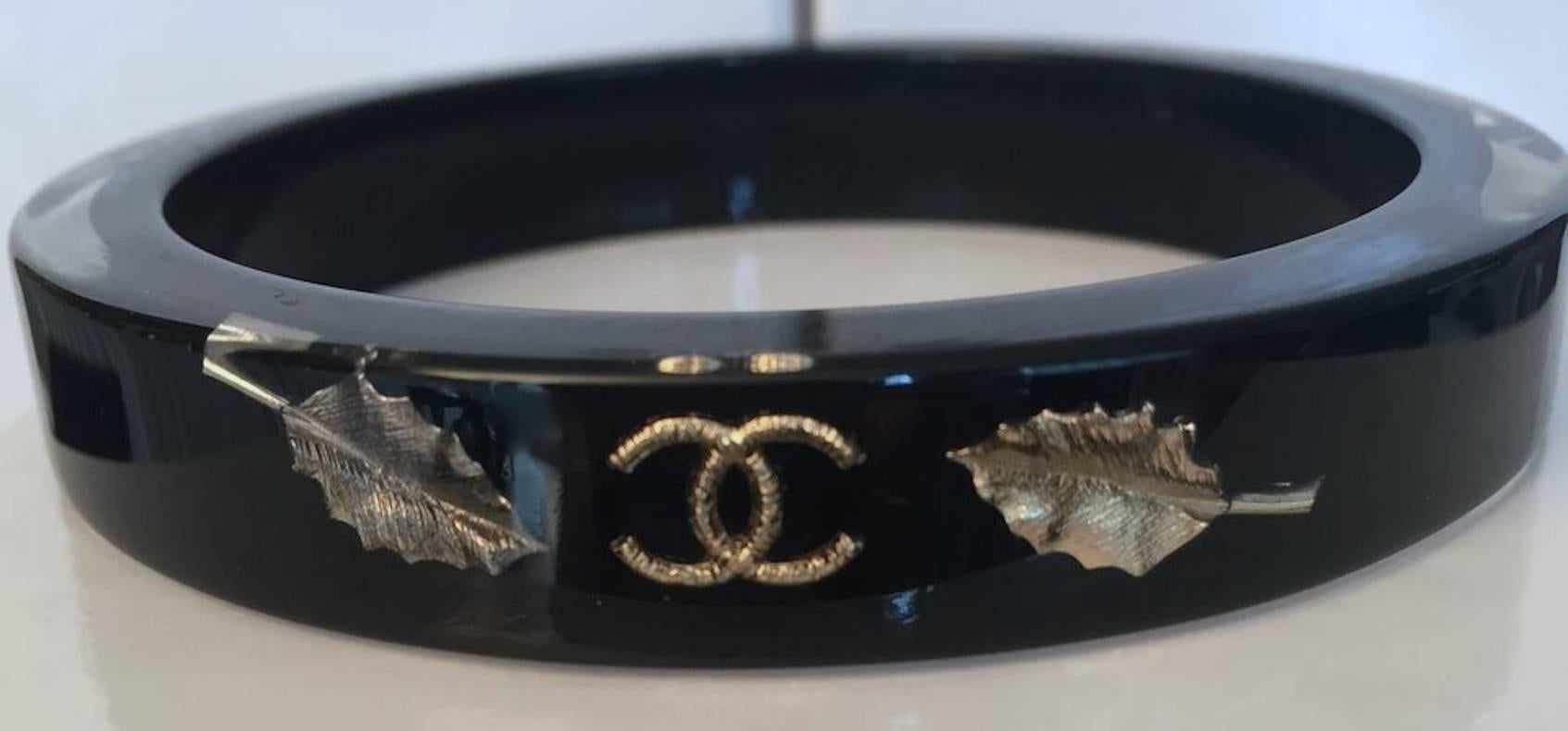 2010's Chanel black resin bracelet with gold and silver leaf motif (repeated 3 times). Stamped official Chanel. Excellent condition, very light wear. 