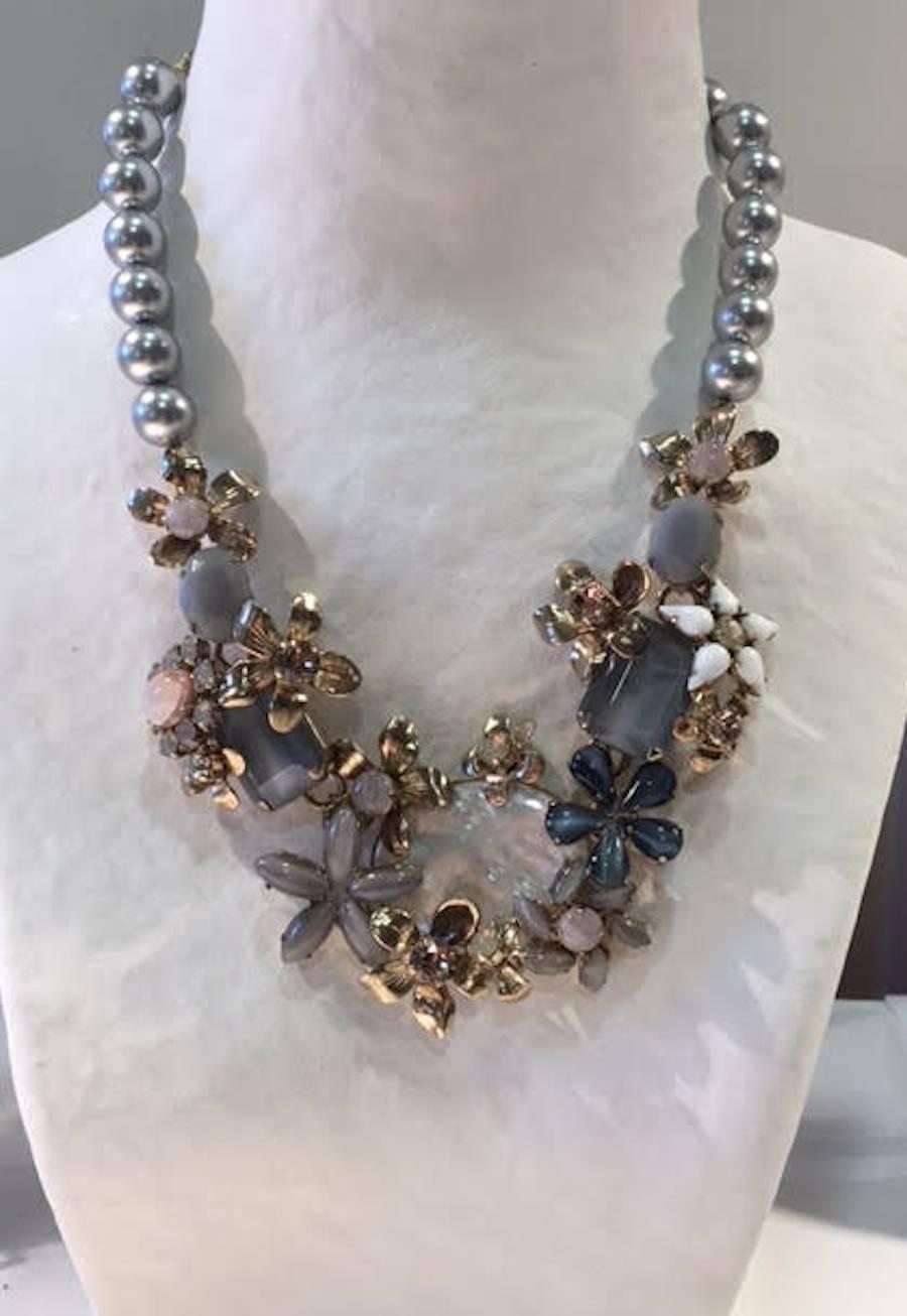 Glass pearl, mother of pearl, glass cabochon, and Swarovski Crystal floral motif necklace from French designer Philippe Ferrandis. 

15