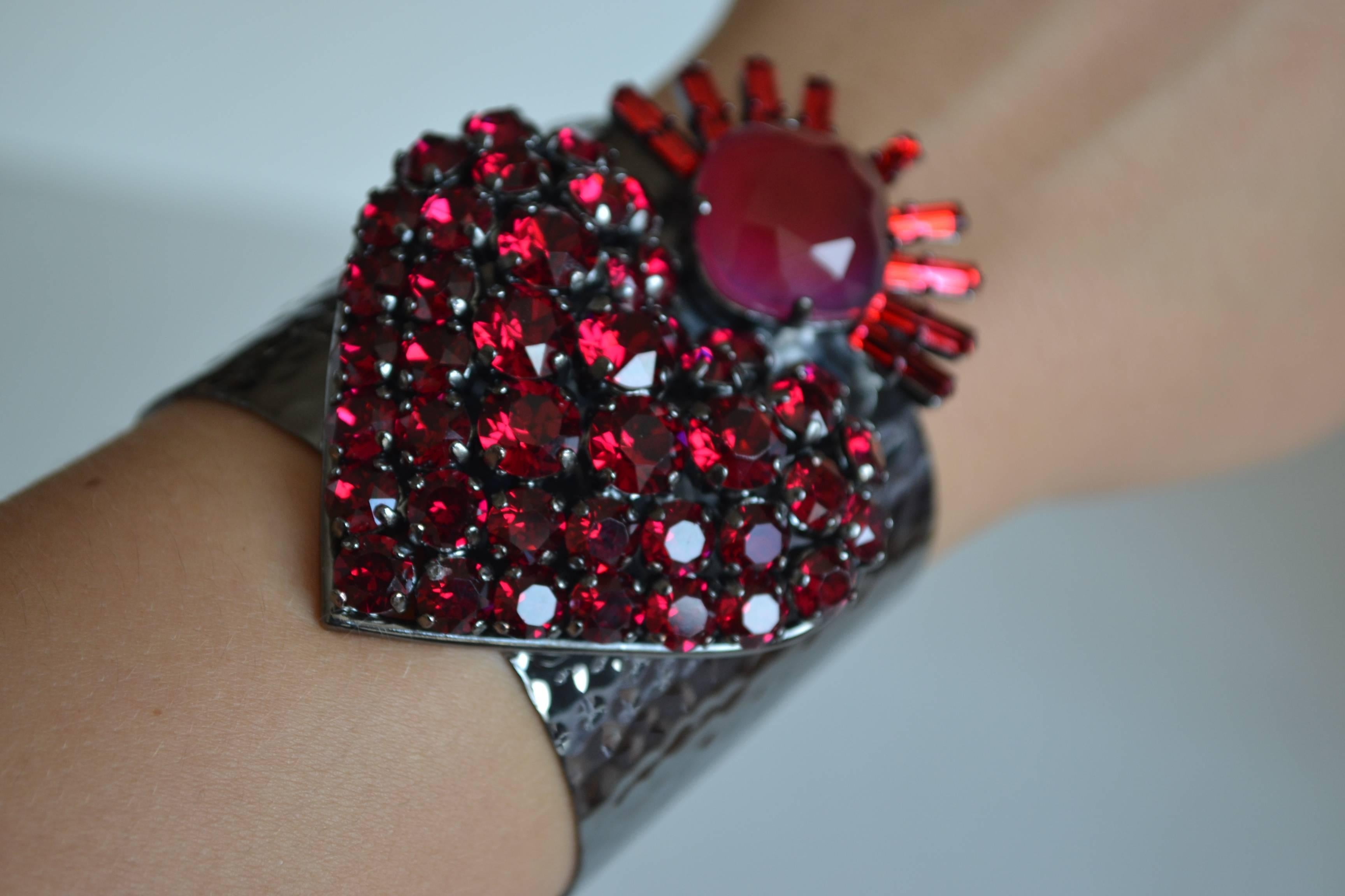 Hammered metal cuff bracelet with red Swarovski Crystals from Philippe Ferrandis. The metal is soft and can be molded to fit most wrist sizes. 

Cuff is 2
