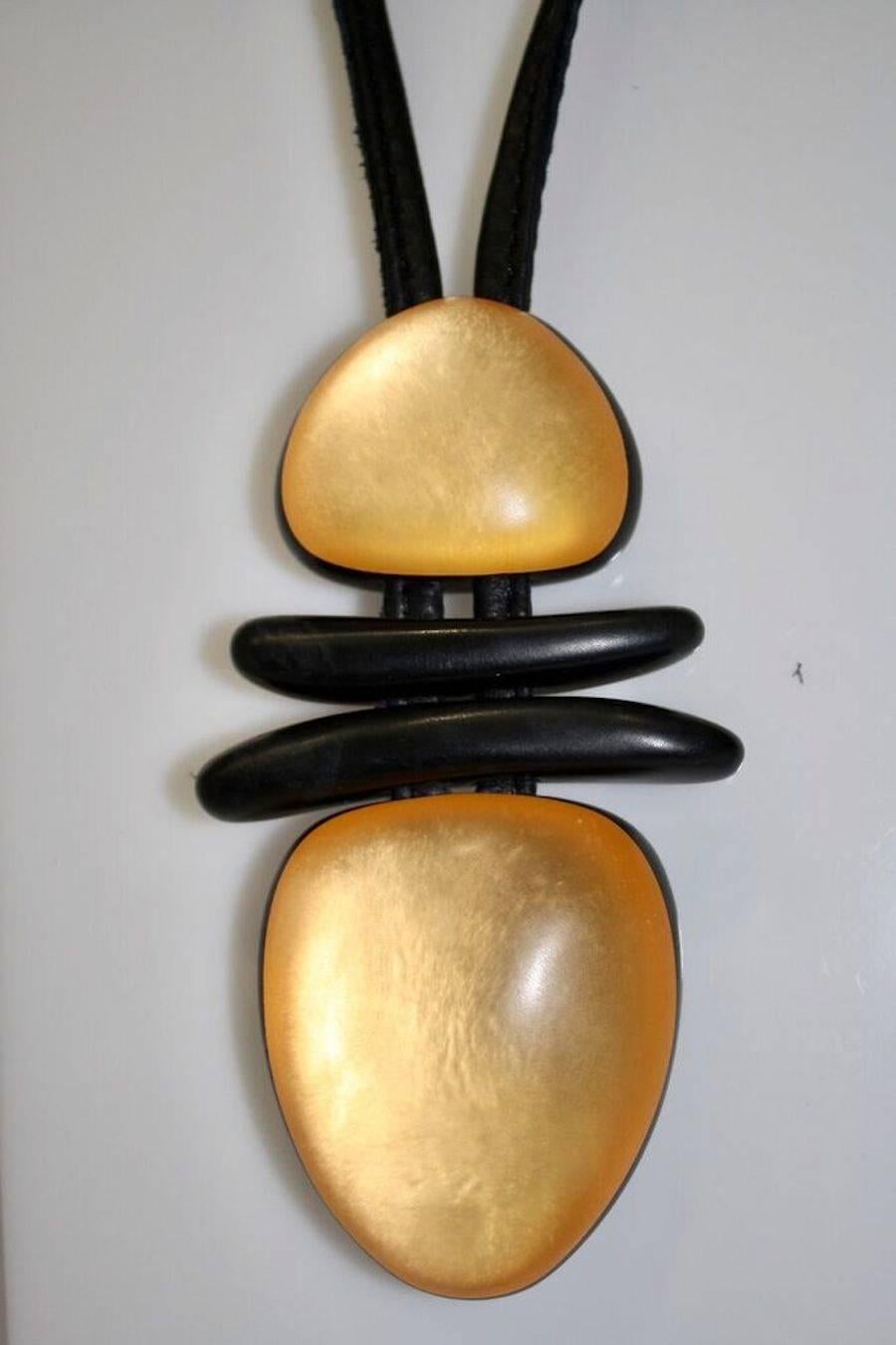 Gold acrylic, ebony wood, and leather pendant necklace from Monies. 

Leather is 24