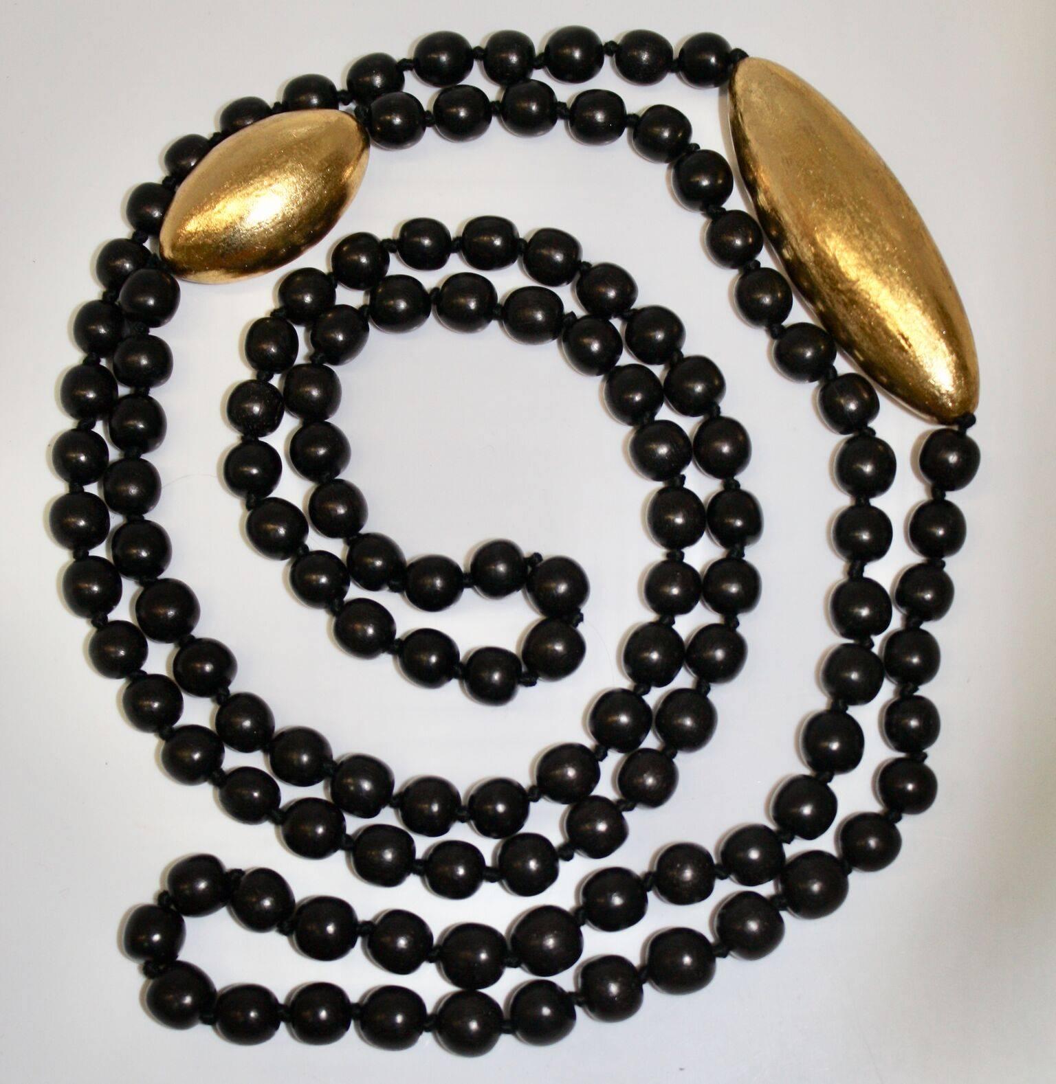 Long wood pearls with two gold leaf elements from Monies. 76