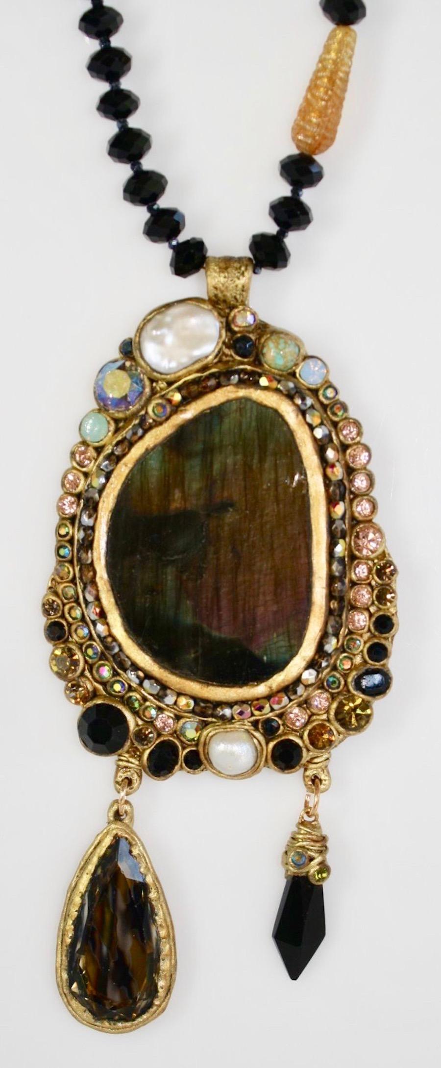 One of a kind Labradorite pendant set on papier mâché surrounded by Swarovski crystals. Black vintage glass beads holds the pendant .