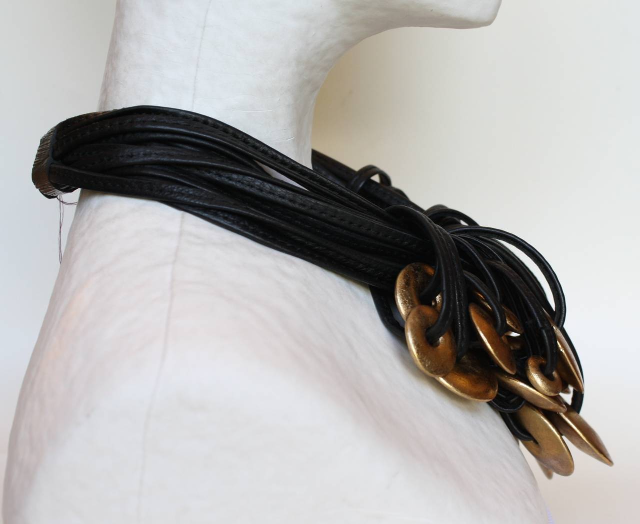Multiple strands of black leather house countless gold foiled wood discs in this unbelievably soft and lightweight modern necklace from Monies. Wood clasp.

18