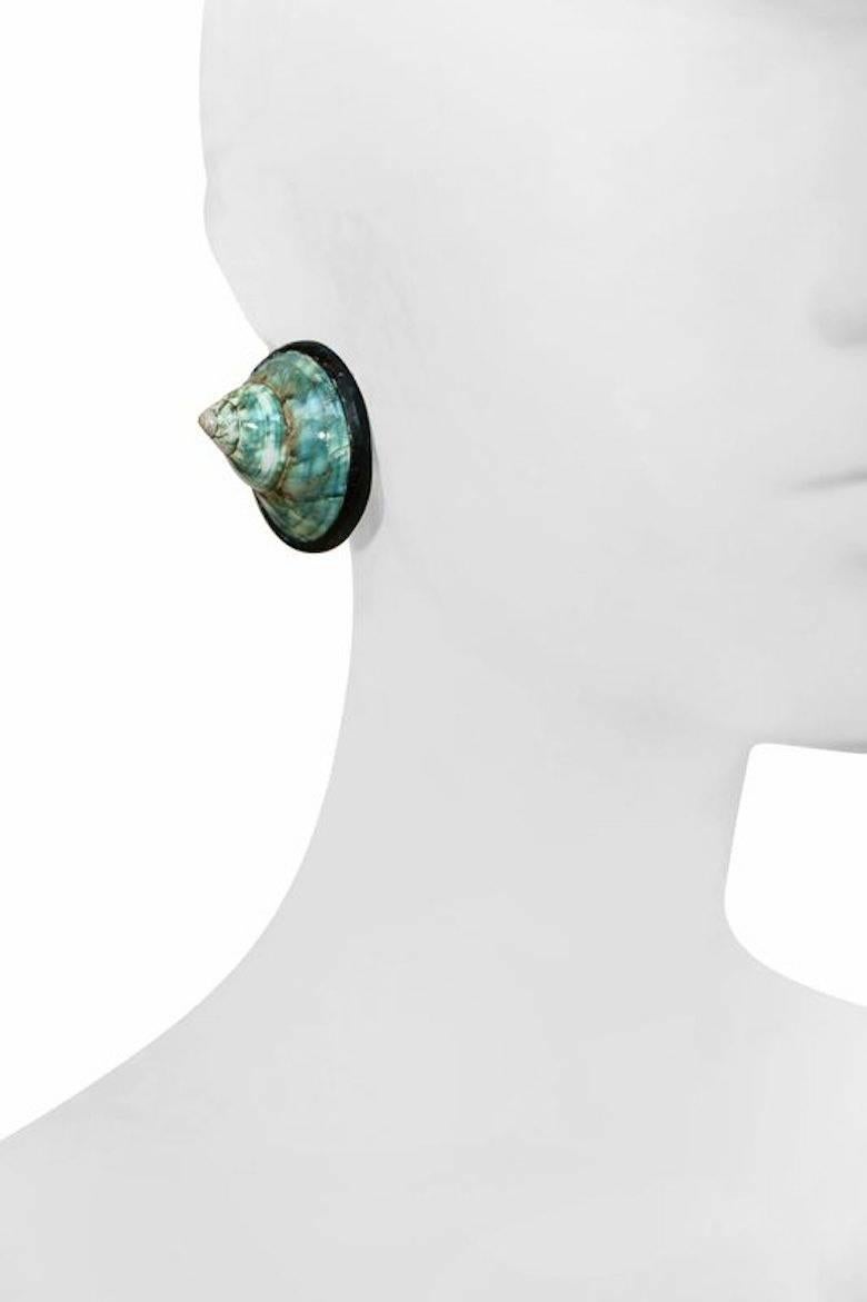 Real shell clip earrings in a beautiful shade of turquoise from Monies.

Designer Biography:

Monies is a Danish jewelry company founded by Gerda and Nikolai Monies. We are trained goldsmiths with experience from Denmark, Germany, England, Italy