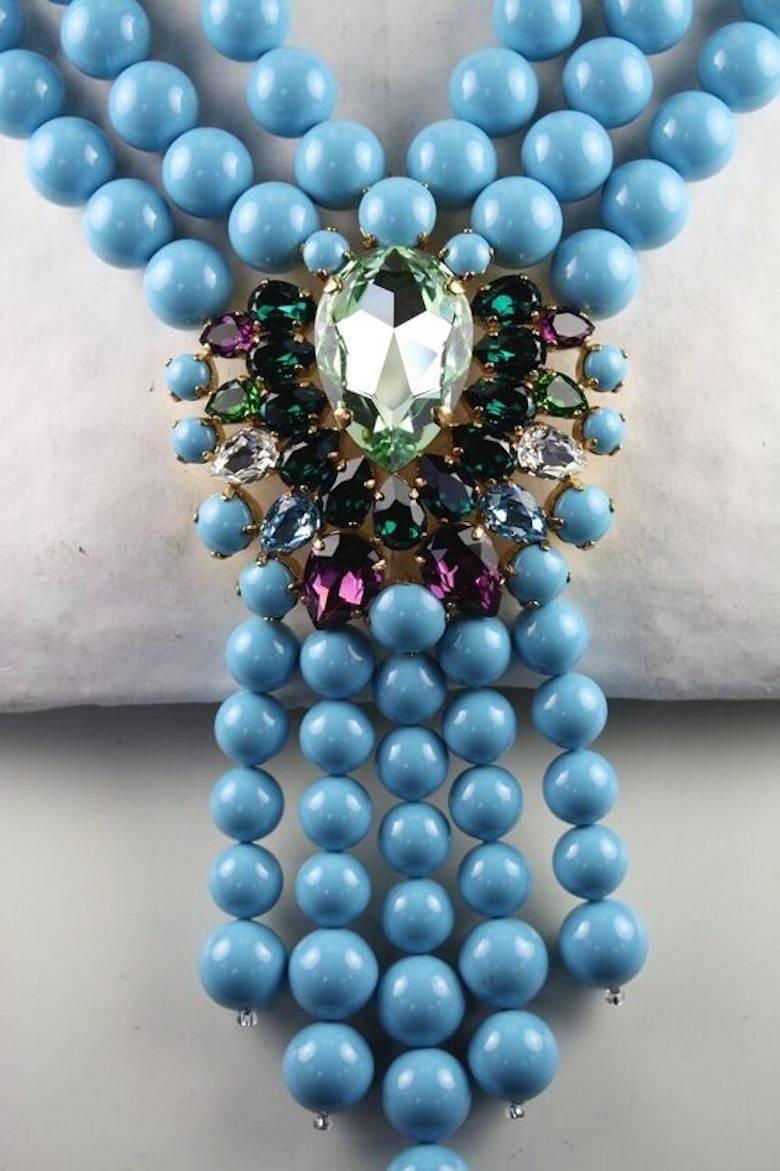 Triple strand turquoise Swarovski crystal pearl cravate necklace with multi color Swarovski crystal detailing from Belgian designer Melissa Kandiyoti. 

14
