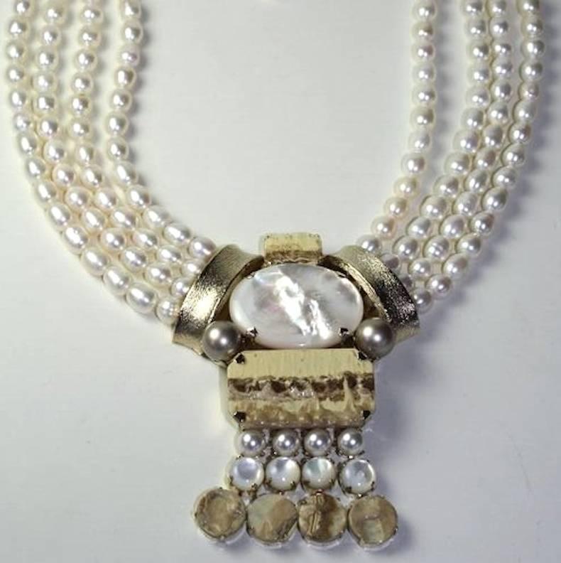 Four rows of glass pearls, mother of pearl, and handmade glass cabochons necklace from Philippe Ferrandis. 

14