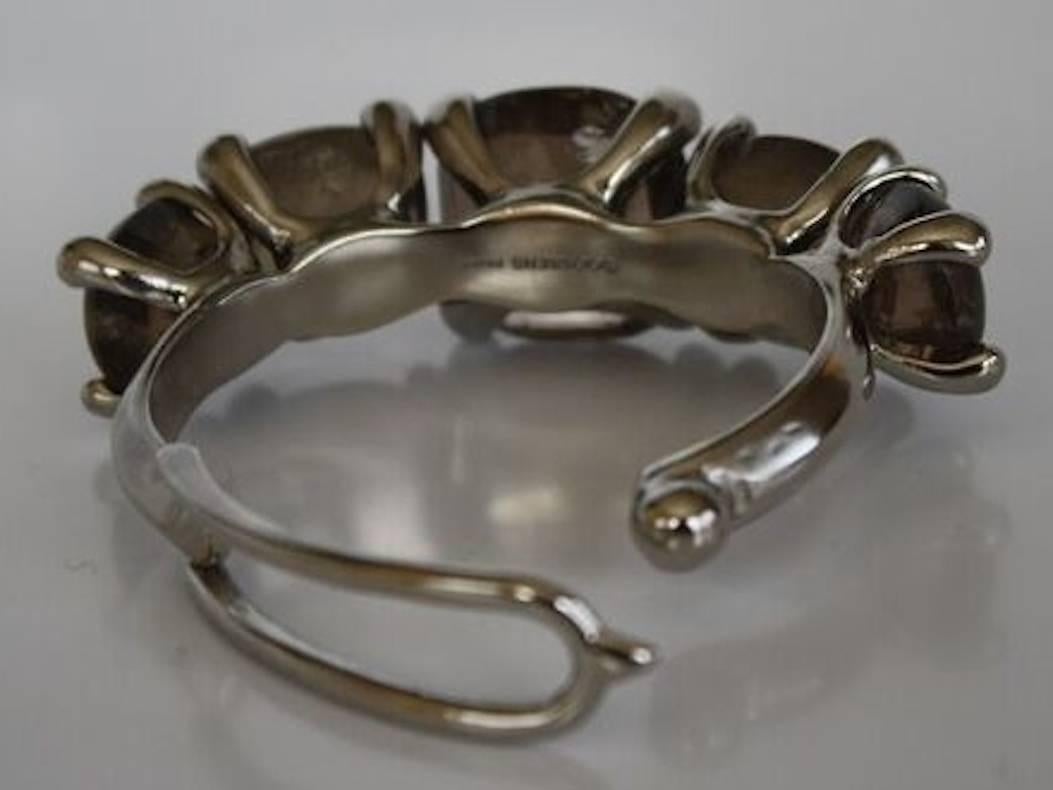 Smokey rock crystals set in a palladium clasped cuff bracelet from Goossens Paris. 