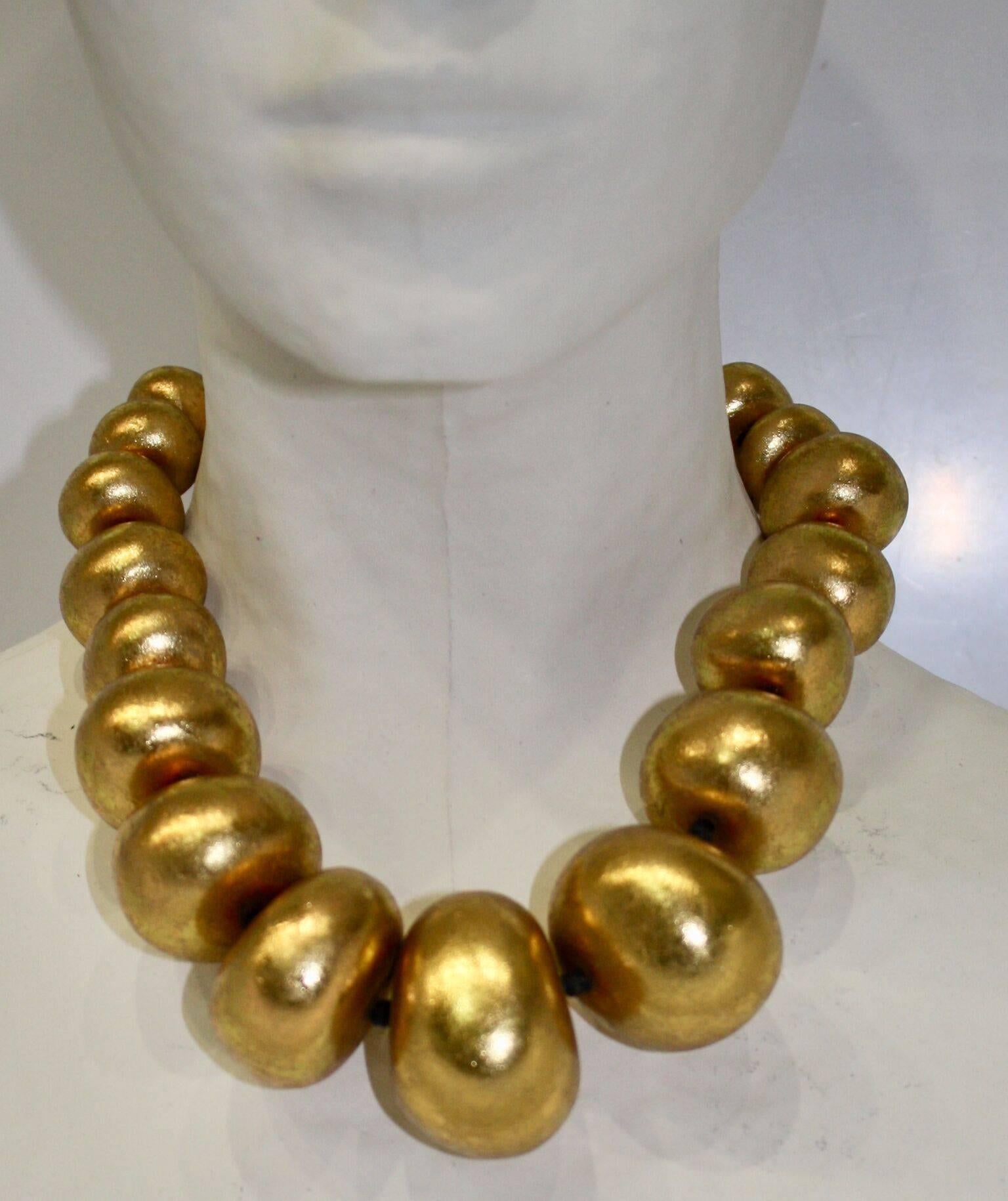 Graduating size ball gold leaf coated wood choker necklace from Monies.  Smallest ball is 1.5