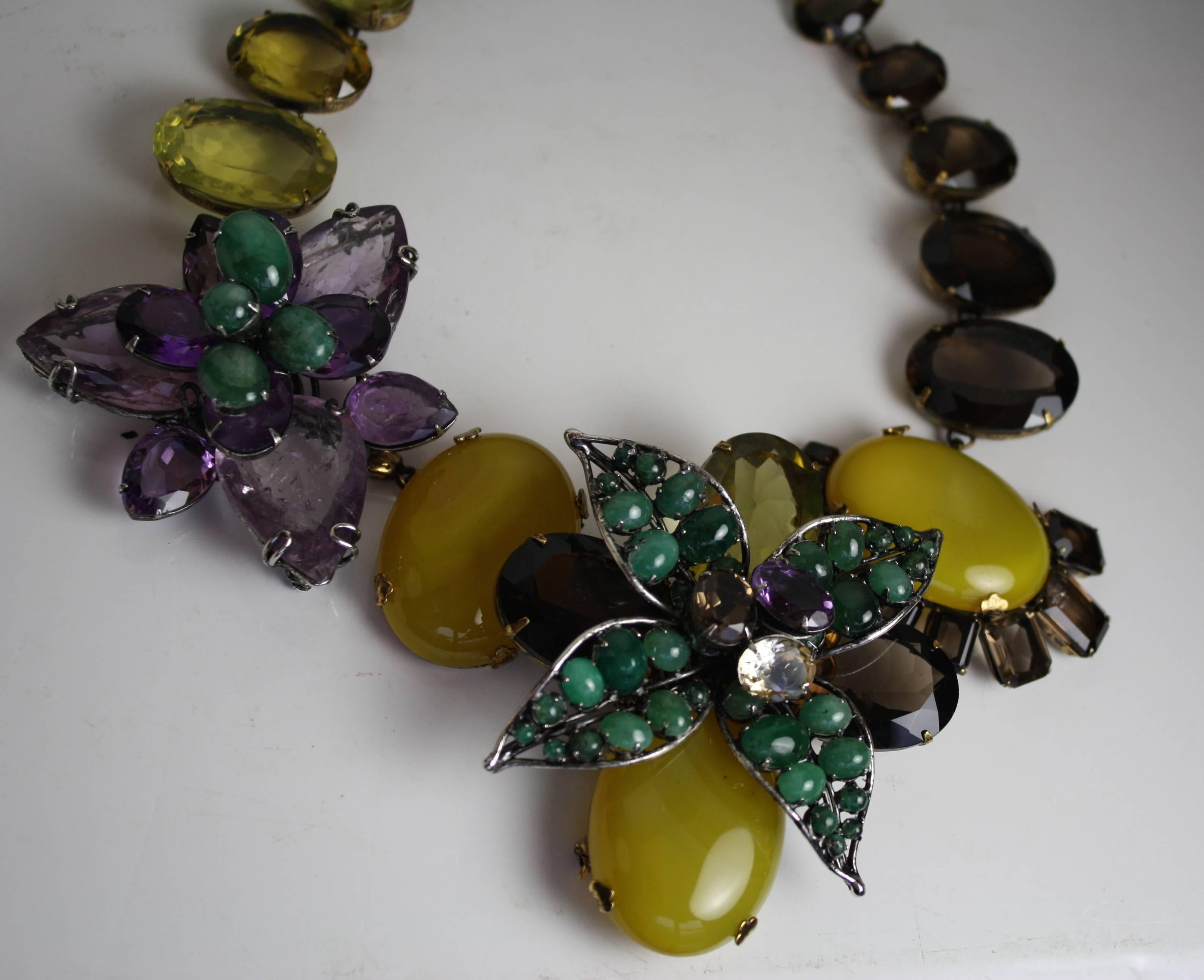 Iradj Moini amethyst, emerald, and quartz double flower choker necklace. Flowers are removable and can be worn separately as pins. 

17.5" width with 3" extra chain
Yellow pin 3" x 3.5"
Purple pin 2.5" x