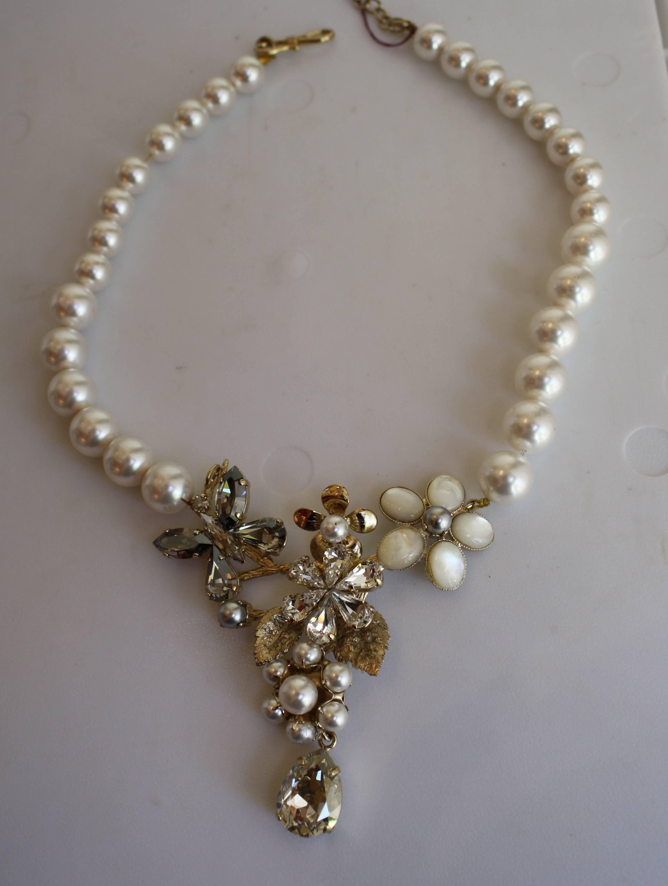 White glass pearls surround a magical mix of Swarovski crystal flowers and butterflies in this beautifully delicate necklace from Philippe Ferrandis. 

16” width with 3.25” extra chain
Motif with drops 3” long

Designer Biography:

Philippe