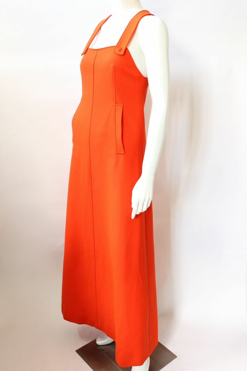 Long a-line orange wool jumper from the Space Age 1967 Collection with snap front crisscross thick straps and slash pockets at hips. Jumper is fully lined and has a back zip.
* Size 0
* 100% Wool
* 100% Acetate Lining
* Excellent Condition -