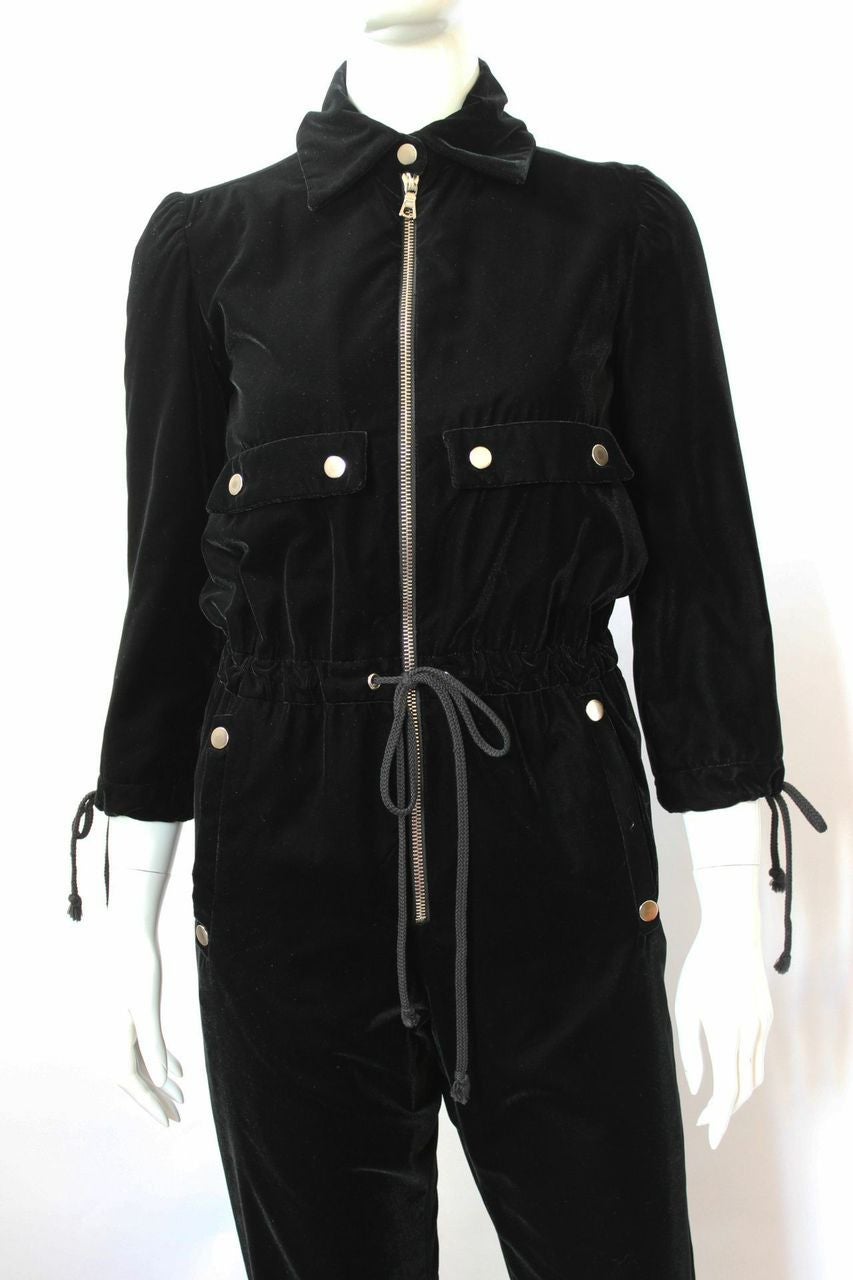 1970s black velvet zip front drawstring waist straight leg jumpsuit with collar and cropped sleeves. The fully lined jumpsuit has faux chest patch pockets, hip and back pockets with silvertone snaps and a tab with snap detail at the small of the