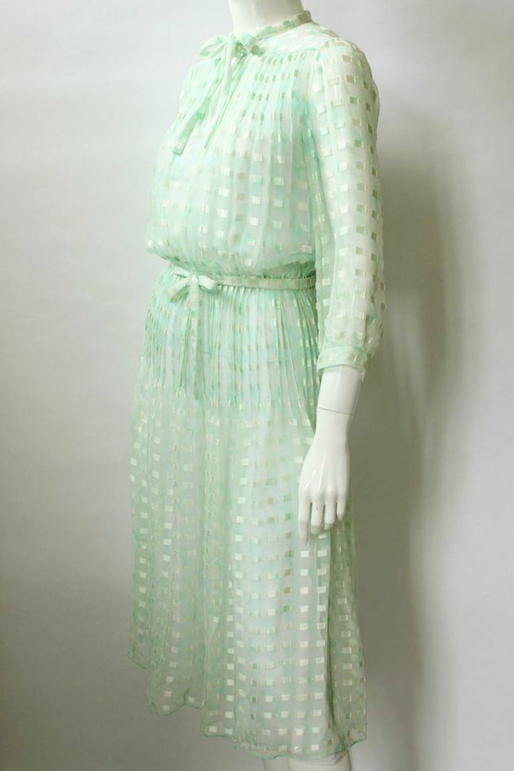 Courreges Paris 1970s Green Silk Lawn Dress  
Shades of green subtle print sheer silk lawn vintage dress. Blouson bodice has cropped full sleeves, small sewn down pintuck pleats across the chest and a button and keyhole opening with ties at the