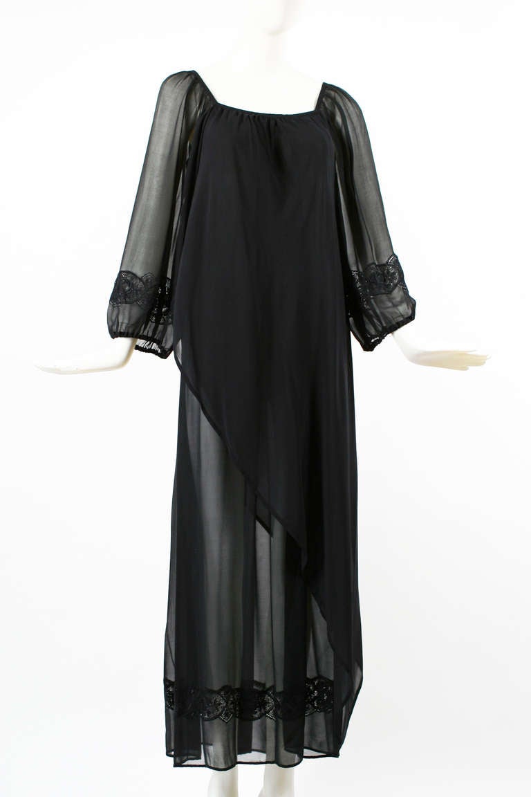 Andrea Odicini 1970s Black Silk Chiffon Embroidered Peasant Dress.
A gorgeous peasant style dress with gathered sleeves at wrist and floral embroidery. The dress is made of sheer panels that reveal the upper leg. Hem has embroidery as well. Sexy as