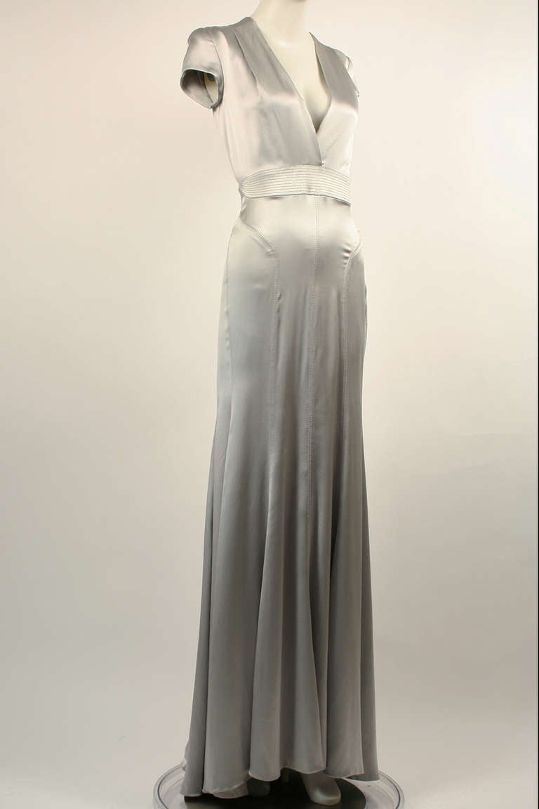 Gianni Versace Couture 1990s Matte Silver Gown. It is made from a gorgeous liquid satin material that drapes perfectly over the body. Expert tailoring and perfect seam placement accentuates the figure. Sexy and elegant open back with a plunging