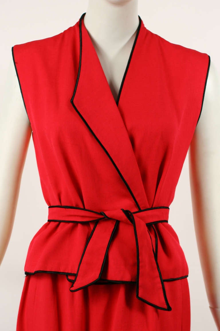 Halston 1970s Red Raw Silk Dress Ensemble.
Black trim piping on top with a highwaisted skirt.  The top has an asymmetrical cut and a wrap style closure that can be adjusted. Attached belt with black piping. Excellent condition.  

Store