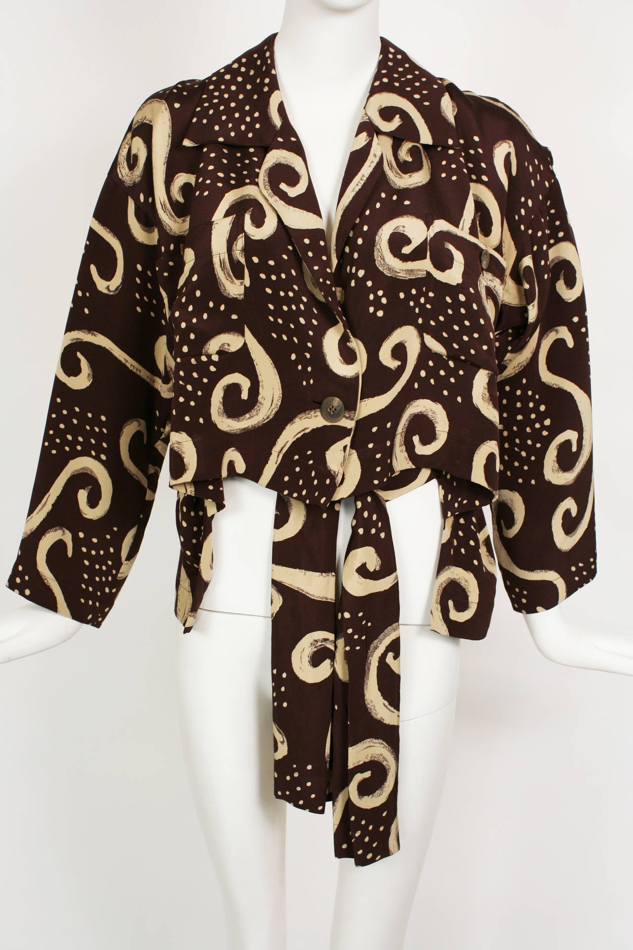 A fabulous and highly collectible Issey Miyake Brown and cream abstract print ensemble. The top has a high-low hem and could work as a light jacket or blouse. The top is doubled silk and has two breast pockets.  The walking shorts are high waisted