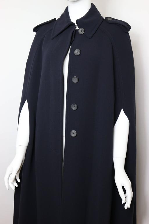 - Gucci by Tom Ford navy wool long cape coat  from fall 1996 collection. Featuring five buttons in front closure, epaulette design. 

- Made in Italy. 

- Size 42. 

- Length: 43 inches. 

- 100% Wool. 

- Model Kristian Owen was rocking it on the