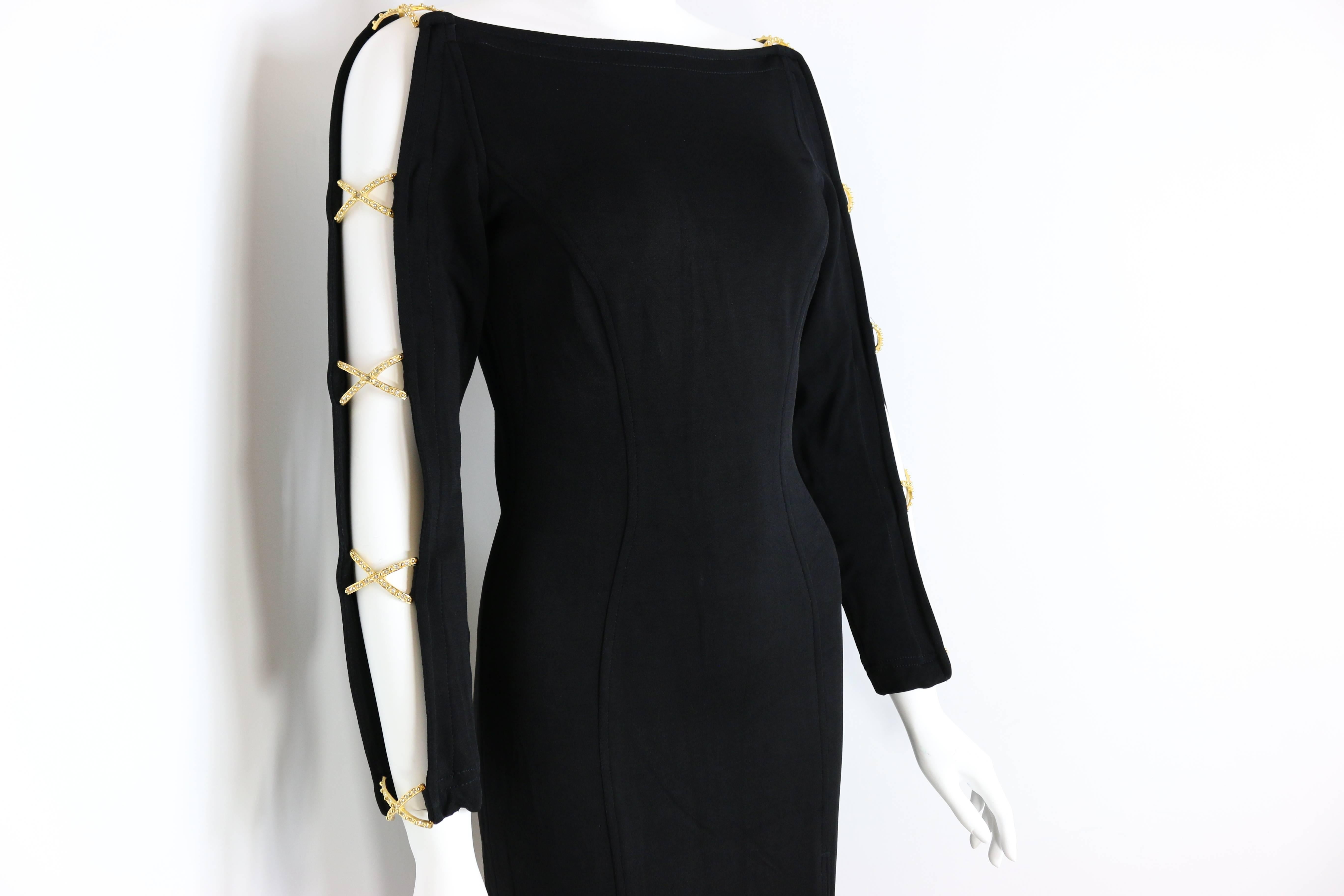 - Vintage 80s Tadashi black jersey dress. 

- Featuring open sleeves design with ten gold rhinestones cross. 

- Split on the front. 

- Back zipper fastening. 

- 82% Rayon, 10% Nylon, 8% Lycra. 

- Size Small. 