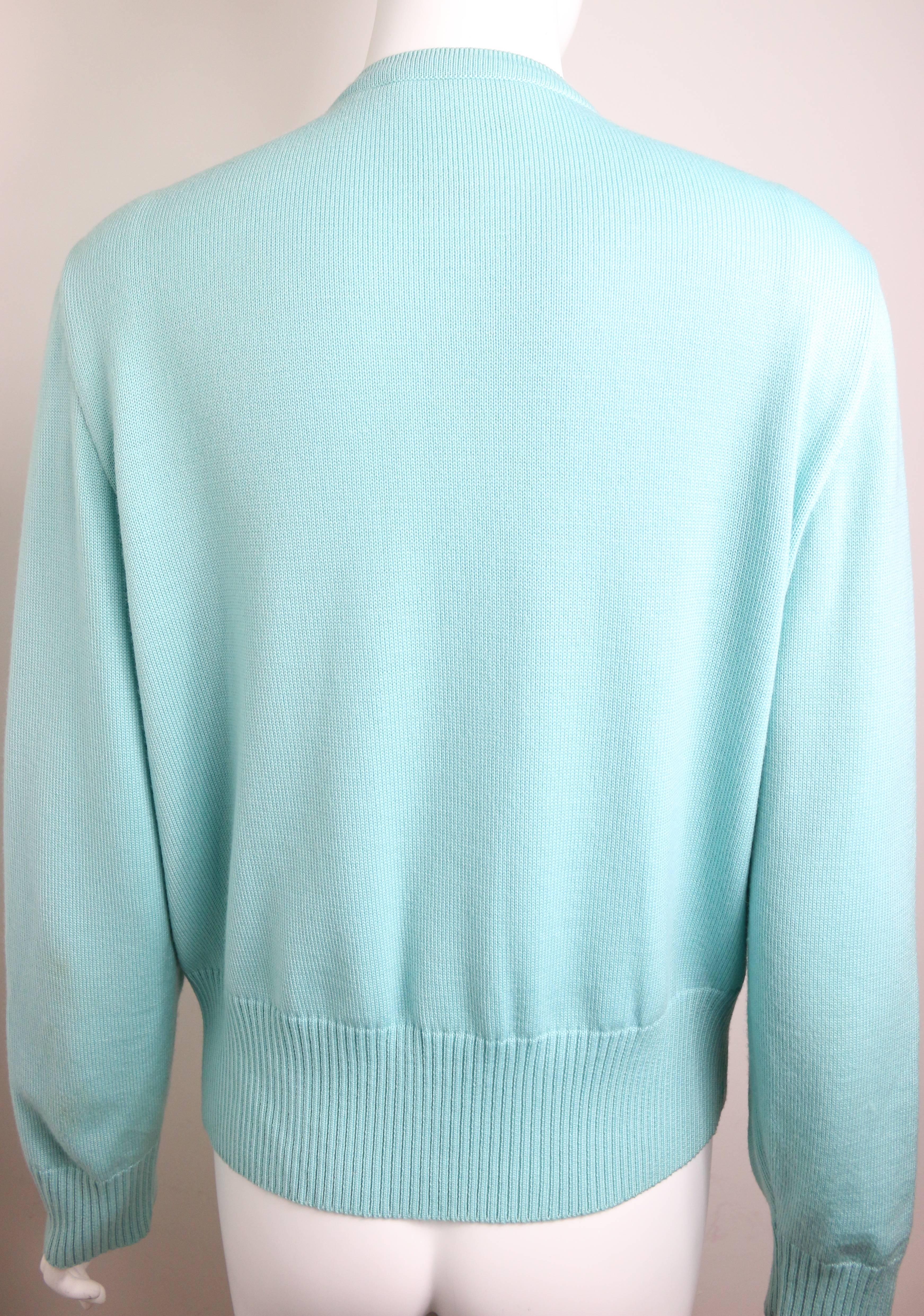 - Pull cardigan vert menthe perlé Escada Vintage des années 80. 

- Fabriqué en Allemagne. 

- 100% laine mérinos.

- Taille 38. 

- Epaule : 16cm I Manches : 62cm I Buste : 36cm I Taille : 88cm I Hauteur : 60cm. 