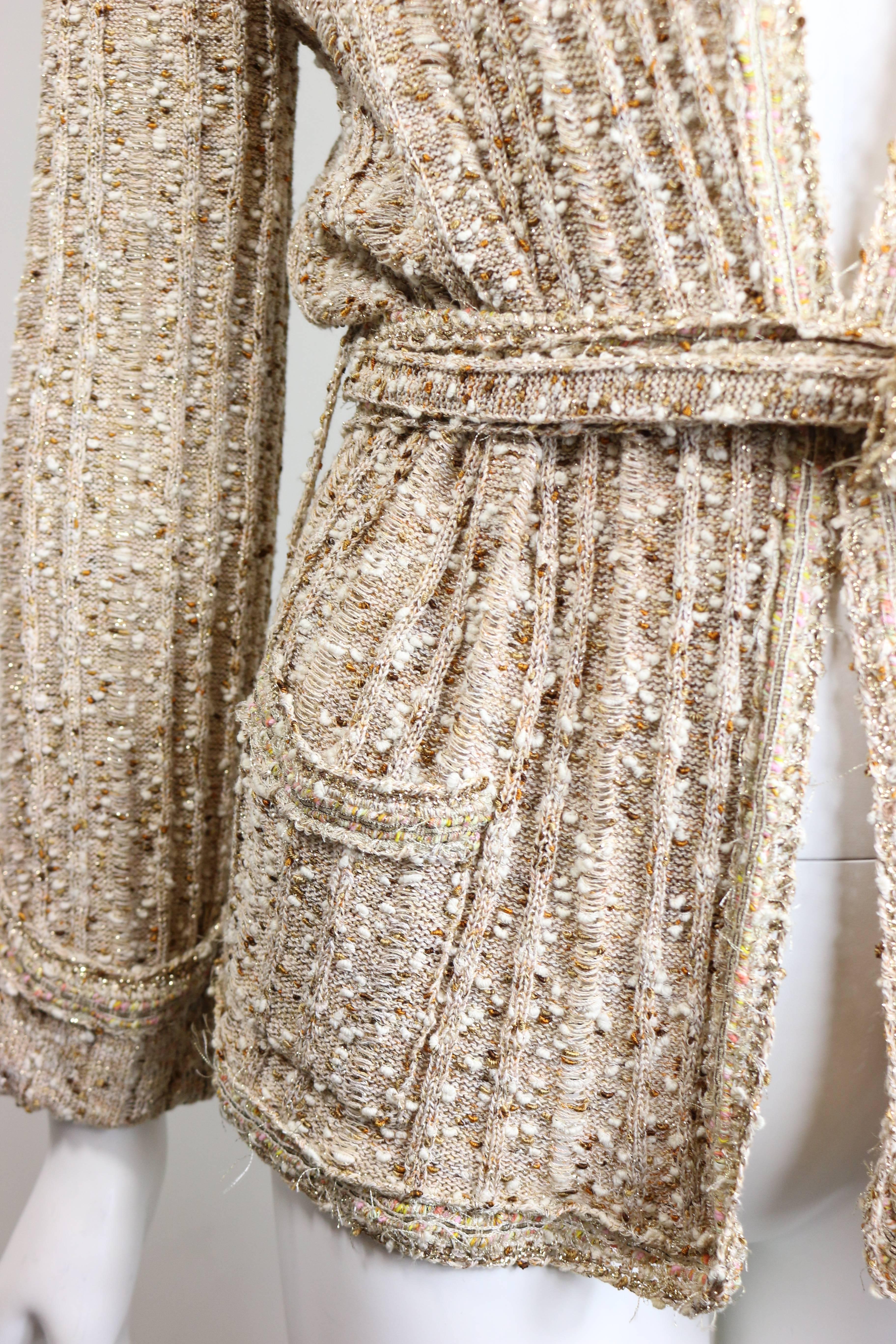 - Chanel beige gold metallic threads and sequins and sash belted cardigan sweater jacket. 

- Size FR 42. 

- 33% Cotton, 26% Rayon, 21% Nylon, 4% Polyamide. 

- Shoulder: 6in I Sleeve: 22in I Bust: 33in I Waist 35in I Height: 25in 