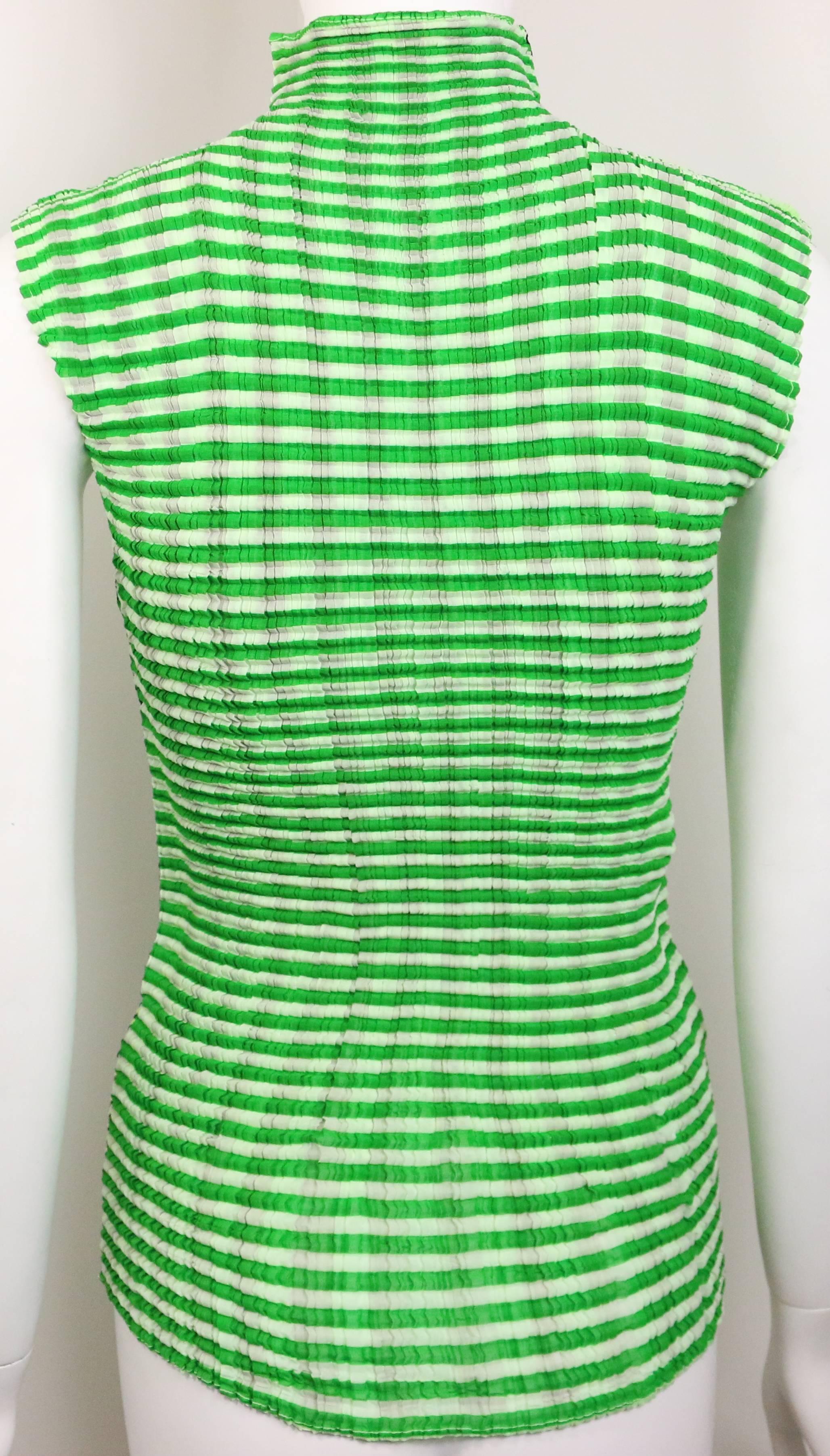 - Plisado Issey Miyake de dos lados( un lado es negro a rayas verticales, blanco y amarillo a rayas horizontales. El otro lado es un top sin mangas con rayas horizontales blancas y verdes. 

- Talla M. 

- 100% poliéster. 

- Fabricado en Japón. 

-