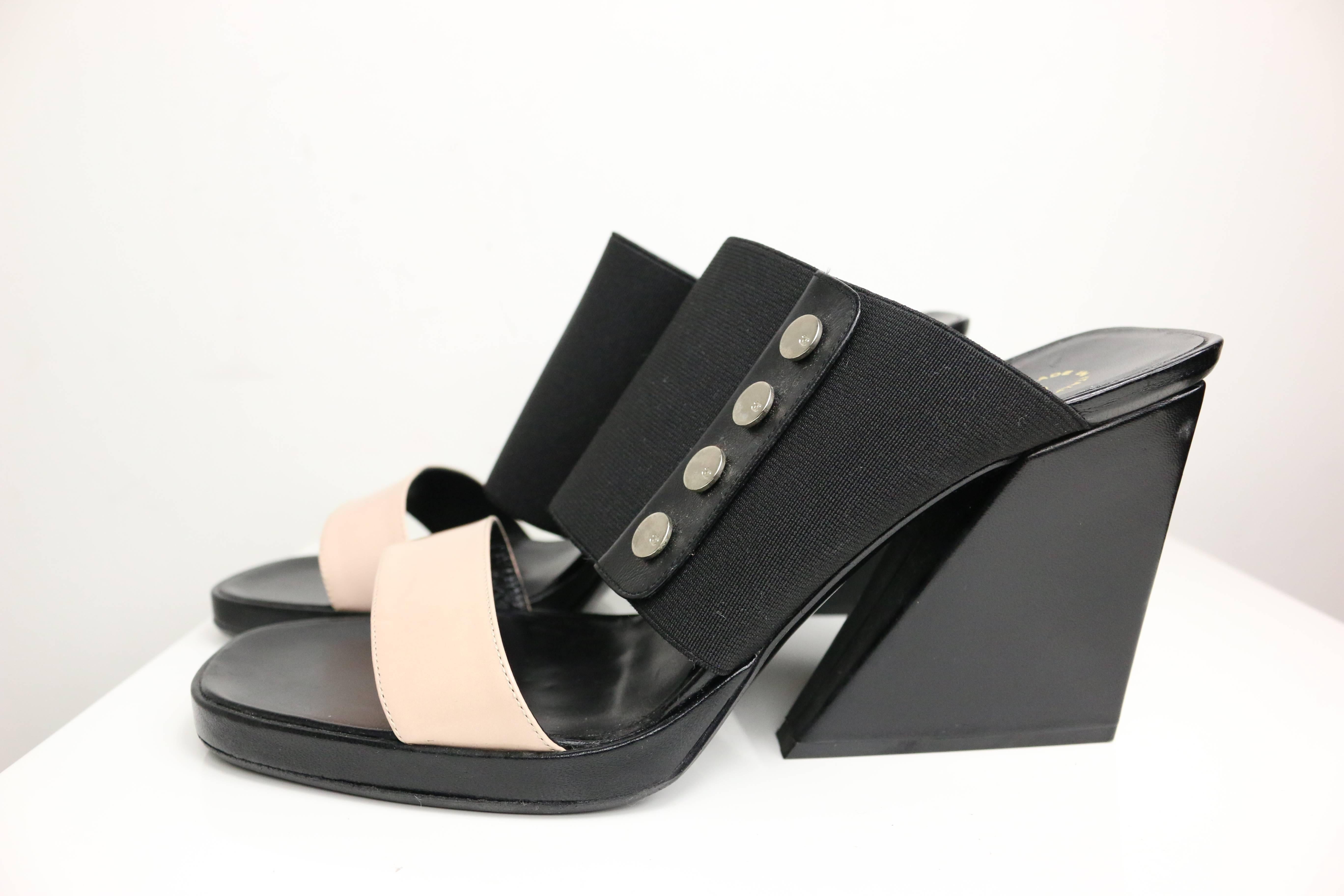 - Chanel bi tone light pink leather strap, black elastic band strap wedge shoes. 

- Featuring four "CC" logo panel metal studs on each wedge. 

- Made in Italy. 

- SIze 38. 

- Height: 4in, Length: 8in ( measurements are approximate).