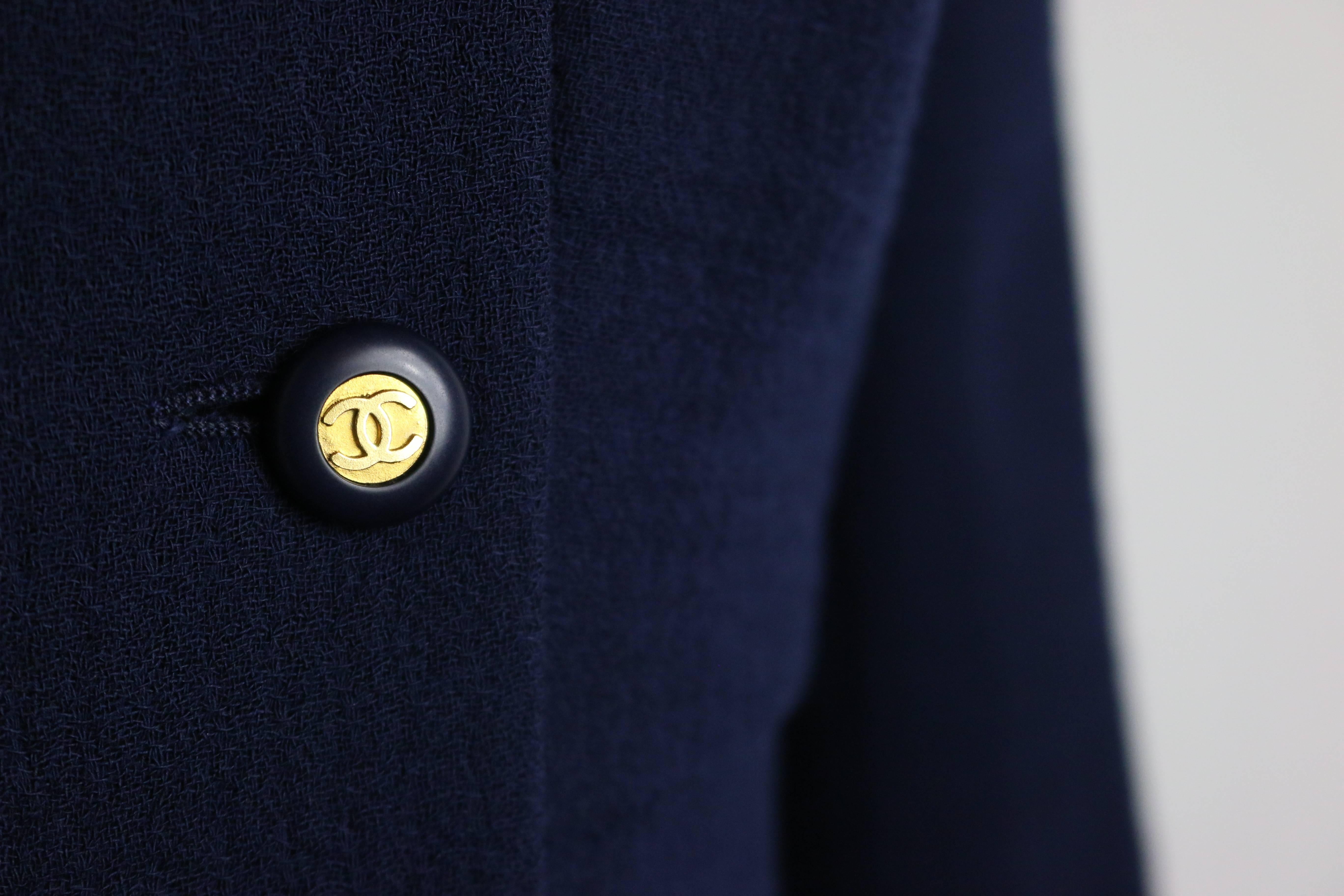 - Chanel dark navy double breasted boucle wool jacket with a flare style bottom from 1994 collection. 

-  Featuring eight panel front gold "CC" logo buttons and three gold "CC" logo buttons on each cuff. 

- Size 38. 

-