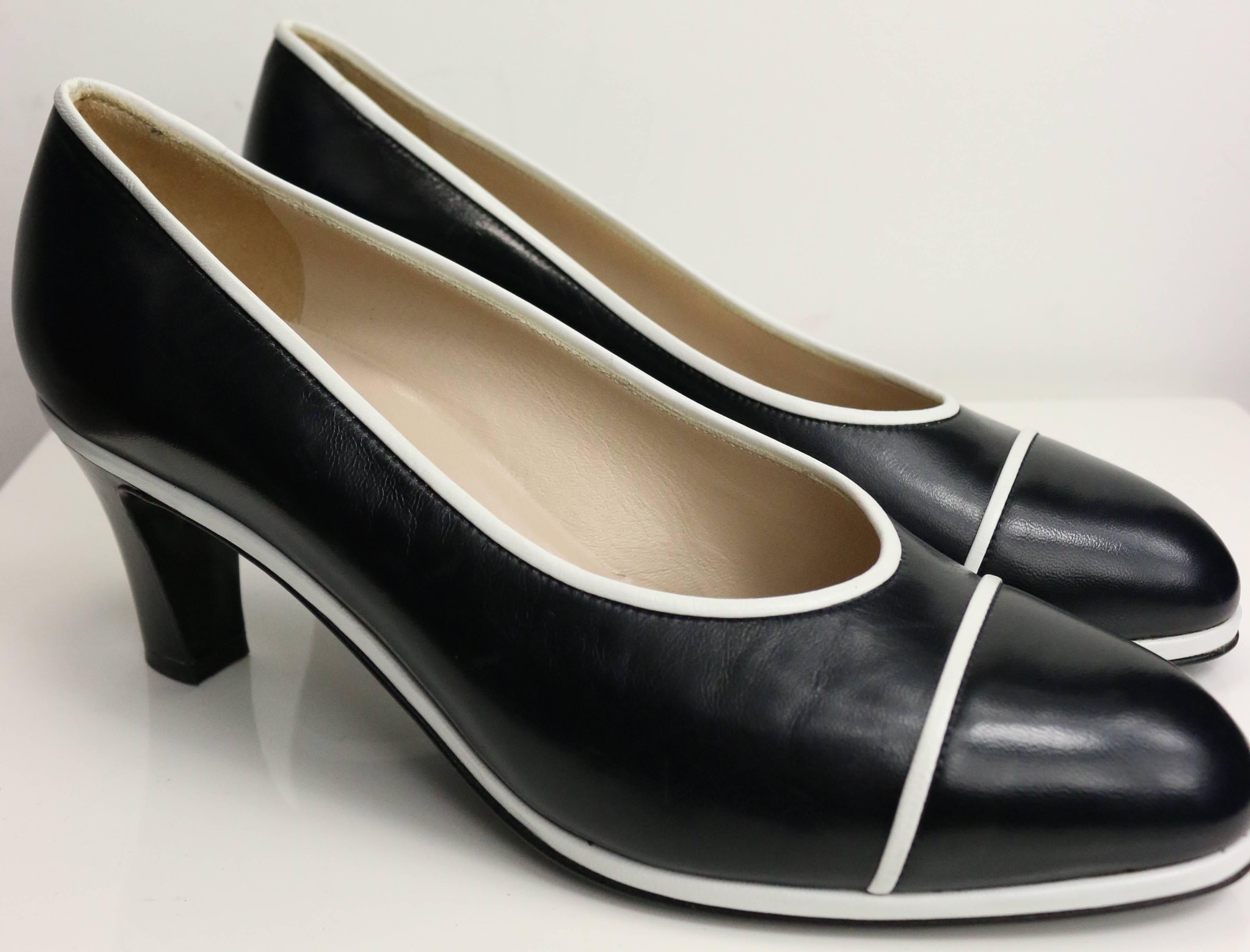 - Vintage 90s Chanel classic black calfskin leather pumps with white piped trim. 

- Made in Italy. 

- Size 37.5. 

- Length: 9 inches.  Heels: 2.5 inches. 

